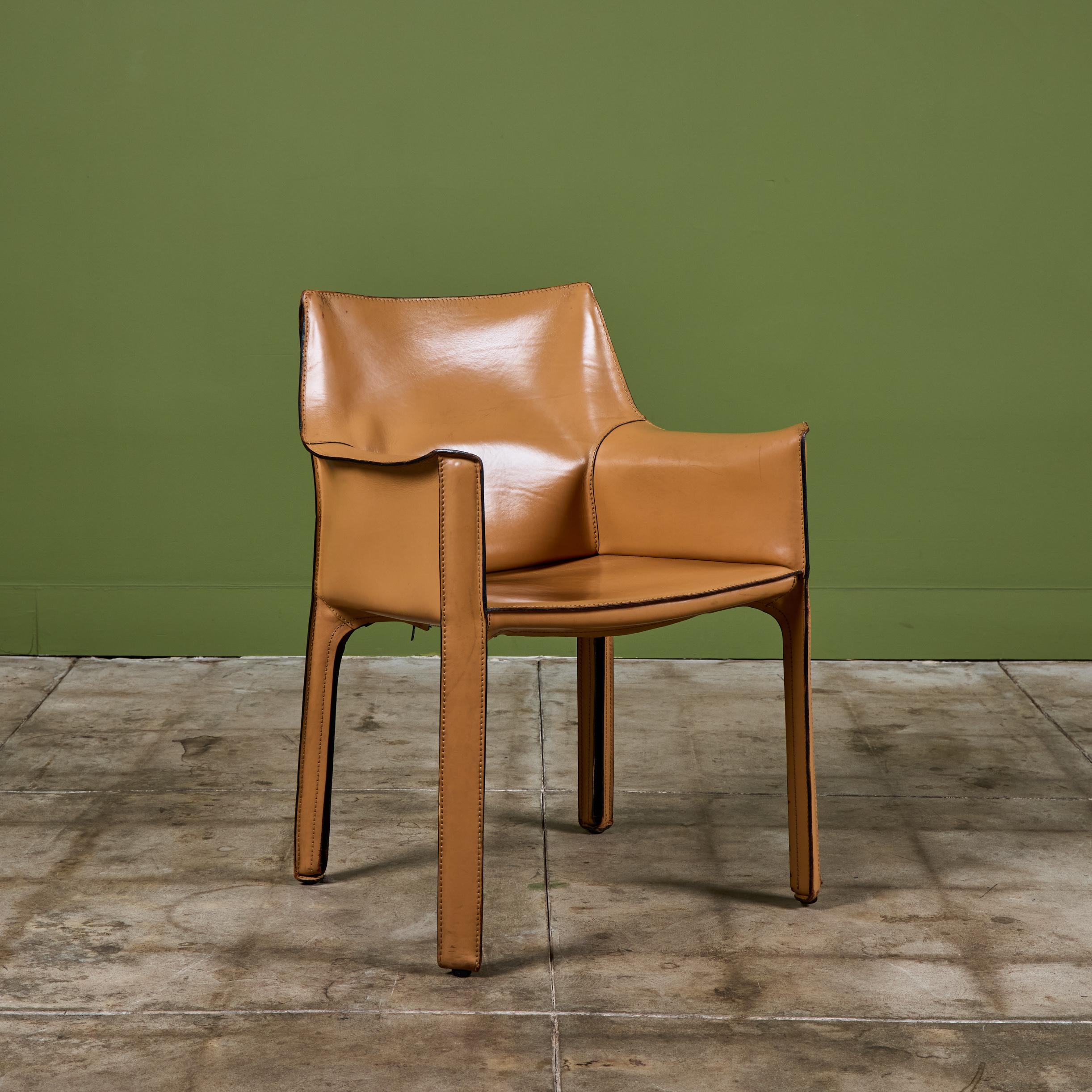 Der ikonische Sessel wurde von Mario Bellini für Cassina in den 1970er Jahren in Italien entworfen und ist mit dem originalen Kamelsattelleder bezogen, das auf den Stahlrahmen aufgelegt ist. Die hinteren Beine sind mit einem schwarzen Reißverschluss