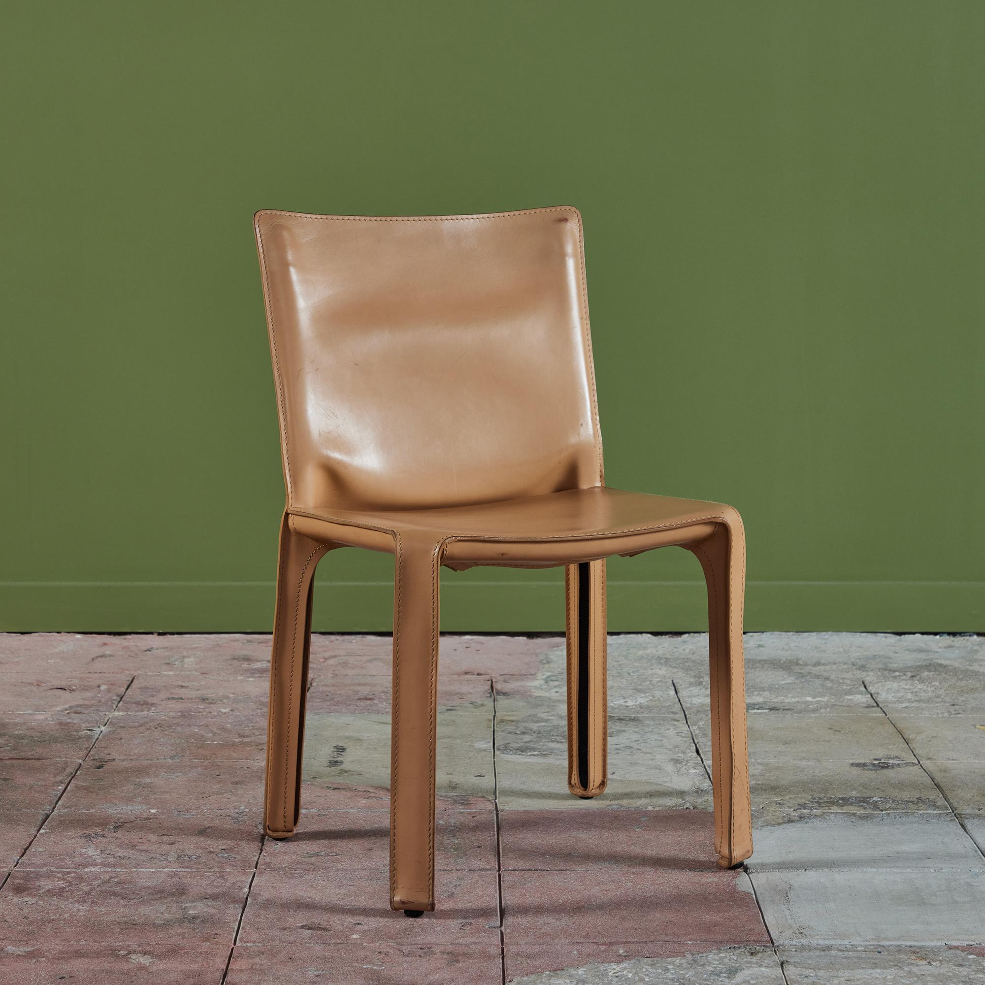 This iconic design by Mario Bellini for Cassina c.1970s, Italy, features the original natural toned saddle leather which is wrapped atop a steel frame. The back of each leg features a black zippered detail. The bottom of the chairs are marked -