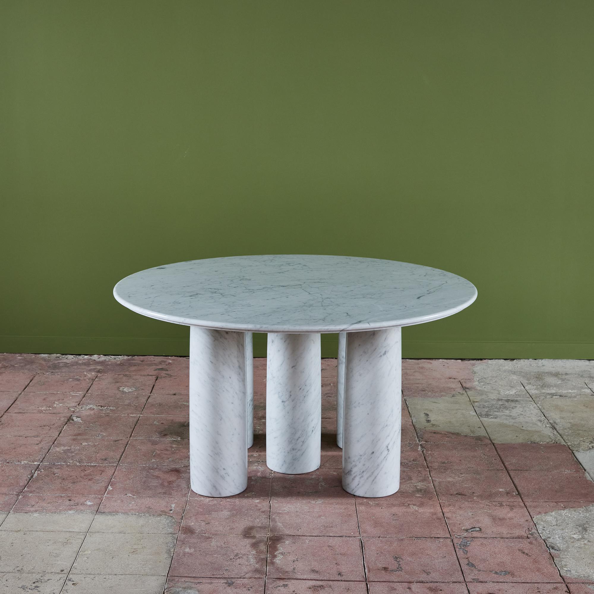 'Il Colonnato' round dining table in Carrara marble by Mario Bellini for Cassina. The table features a thick round white marble top with distinct gray veining. There are five thick column legs that support the tabletop. Bellini designed the table in