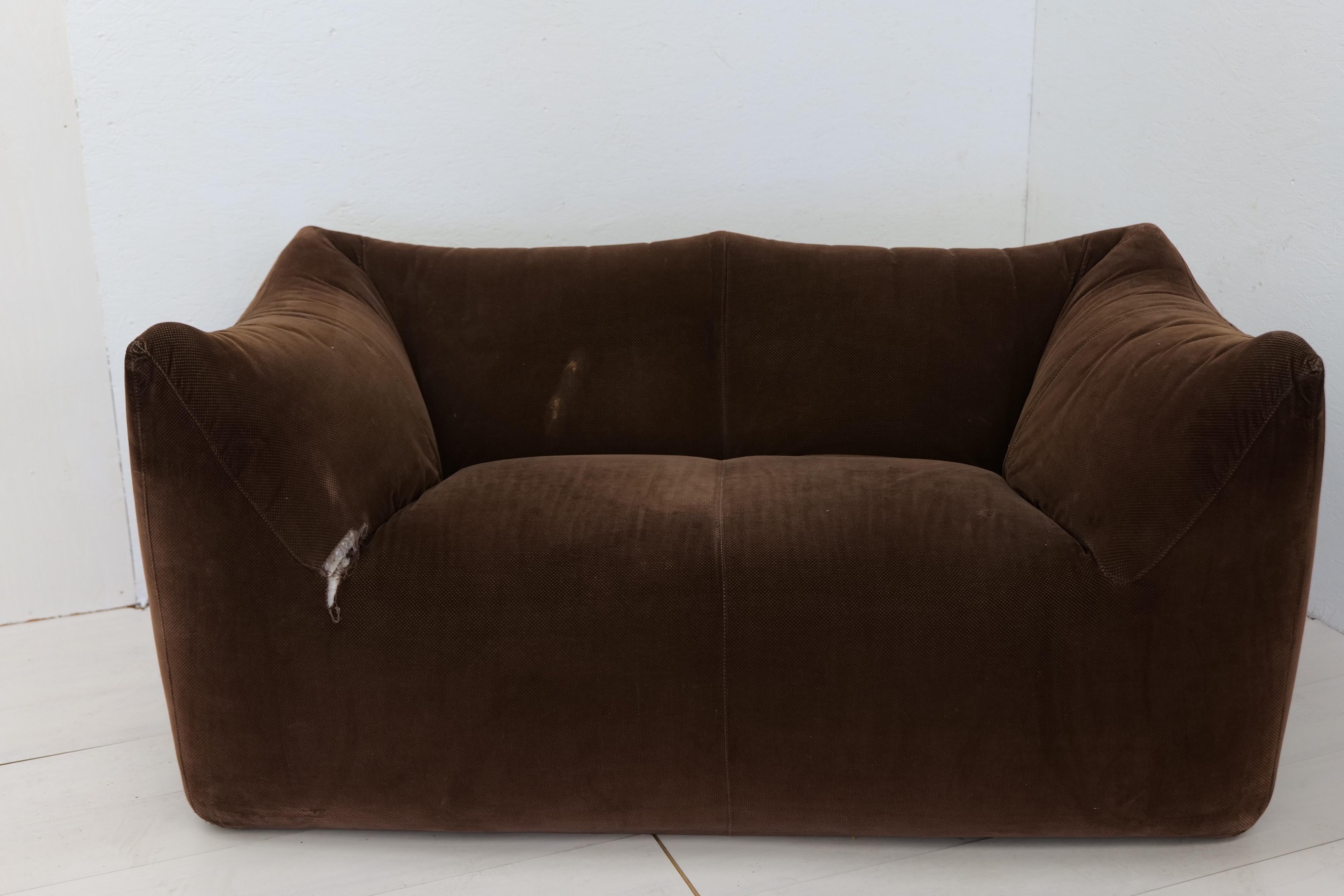 This comfortable brown original fabric settee is bulky and playful, shaped as if it is merely a large cushion and the accompanying feeling is the same. It is designed by Mario Bellini and was the culmination of research into stuffed furniture. In