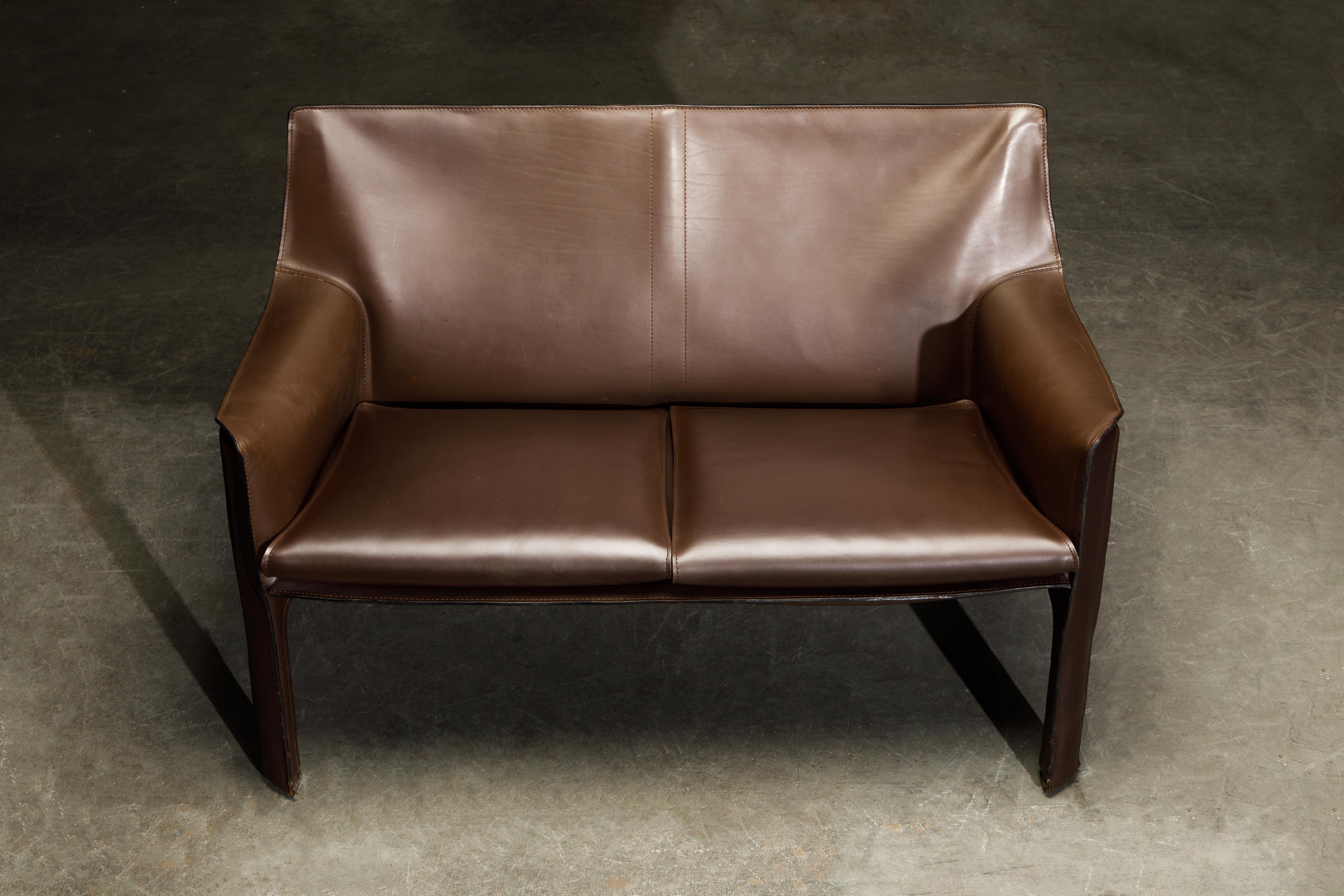 A beautiful Mario Bellini Model #414 'Cab' two-seater sofa in deep brown leather, signed Cassina, designed in the 1970s, this example produced in the early 2000's. These fine examples of the cab line by Mario Bellini for Cassina are classic staples