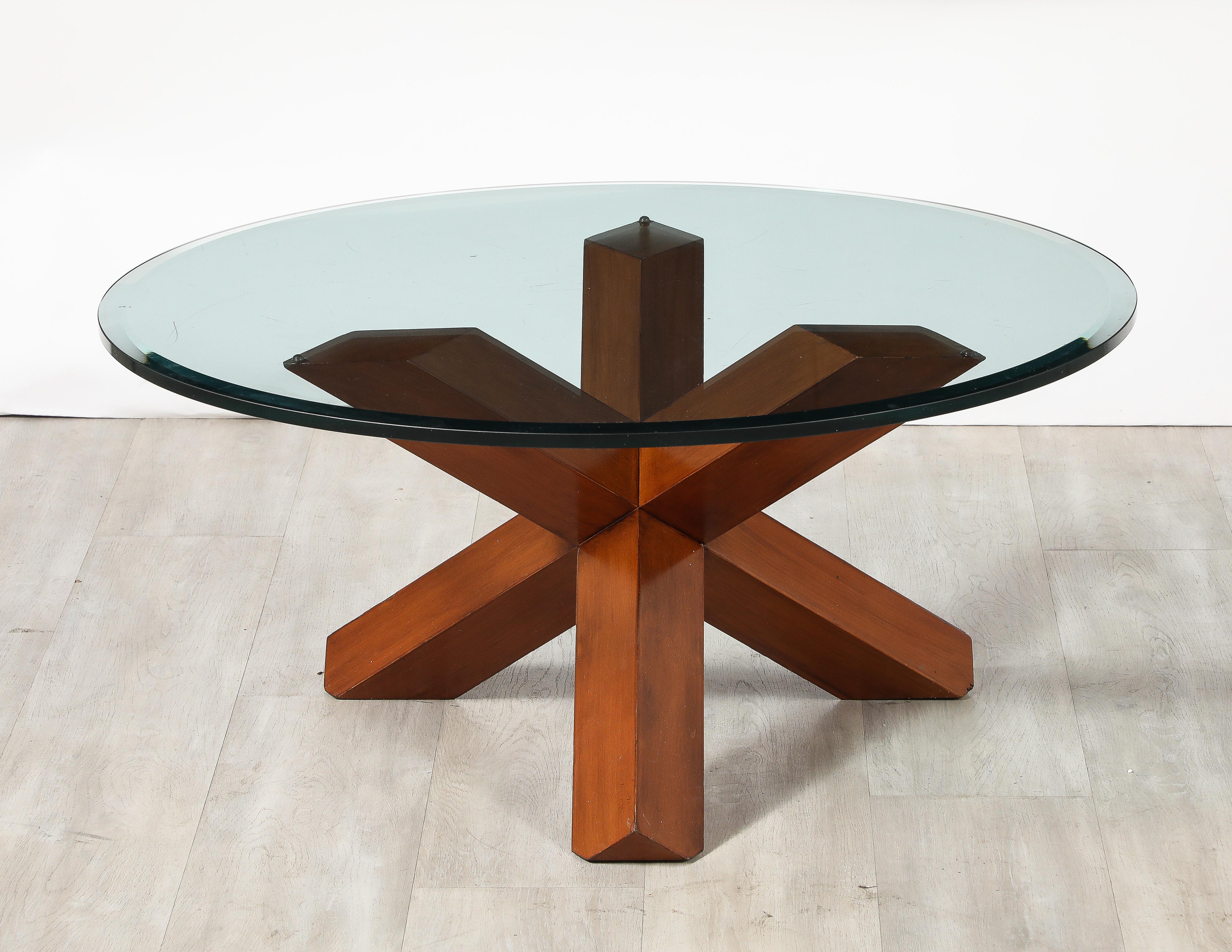 The 'La Rotonda' cocktail table, designed by Mario Bellini for Cassina in 1977, is a stunning representation of modernist design. The thick circular beveled glass top provides for a clear view of the elegant nutwood base below. The rich nutwood,