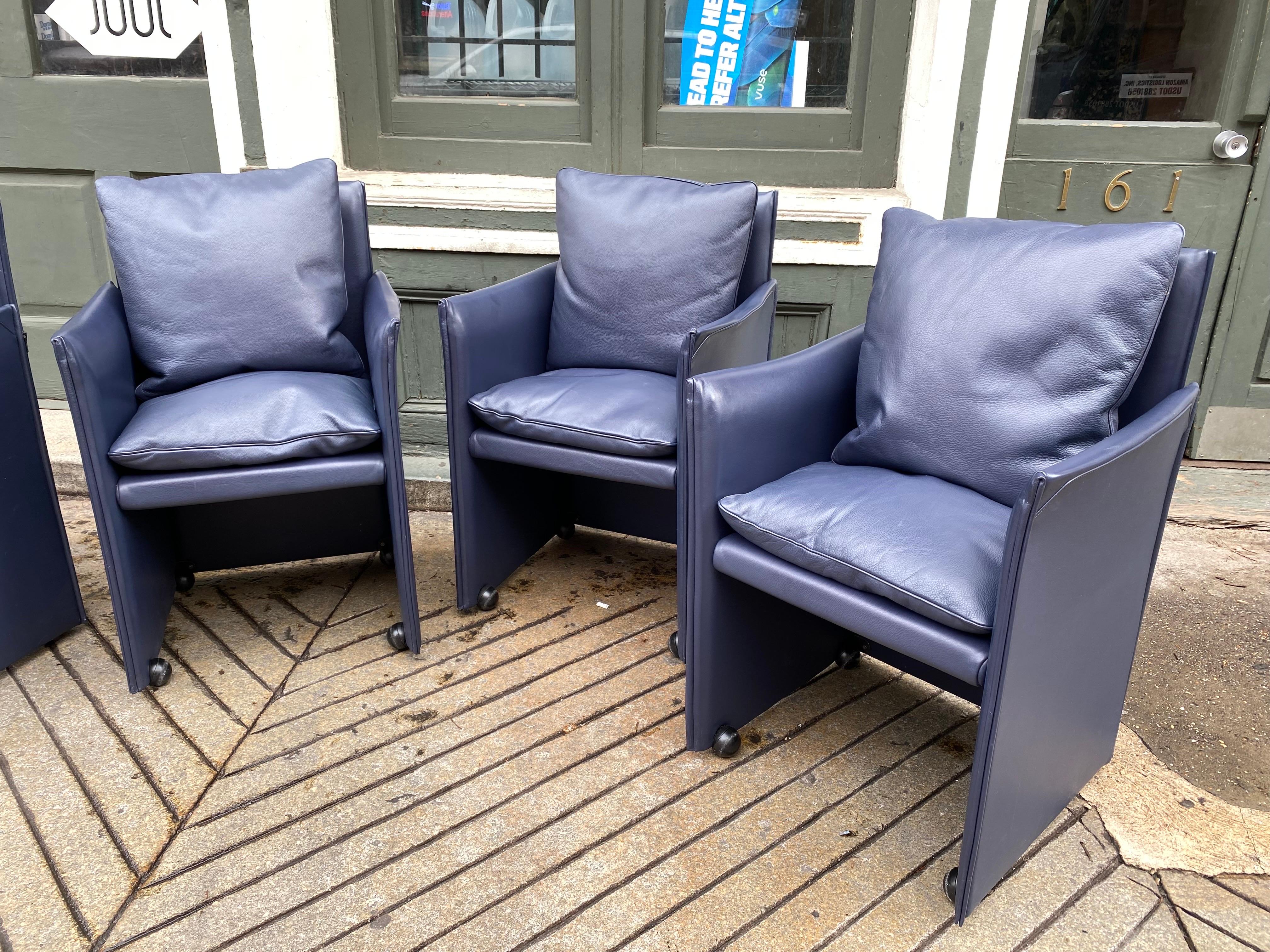 Set of 6 Mario Bellini Break Armchairs in a top grain dark blue leather. Down-filled cushions add style and comfort to these chairs! 2 Additional armless models available as well! Chairs roll easily and still have their back cushions as seen in