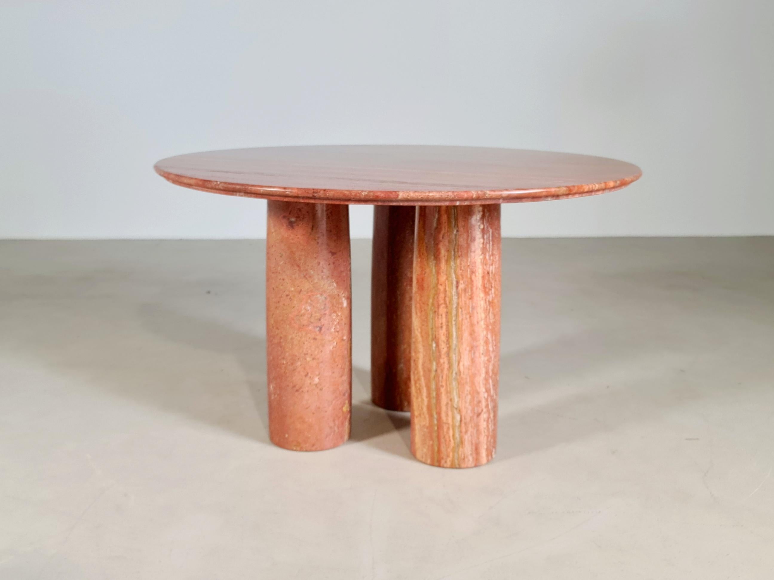 This stunning minimalist table designed by Milanese architect Mario Bellini, is made purely from one material, solid red tufo marble. A round top on three cylindrical columns. This exact version is a very rare thing to come across as it was produced