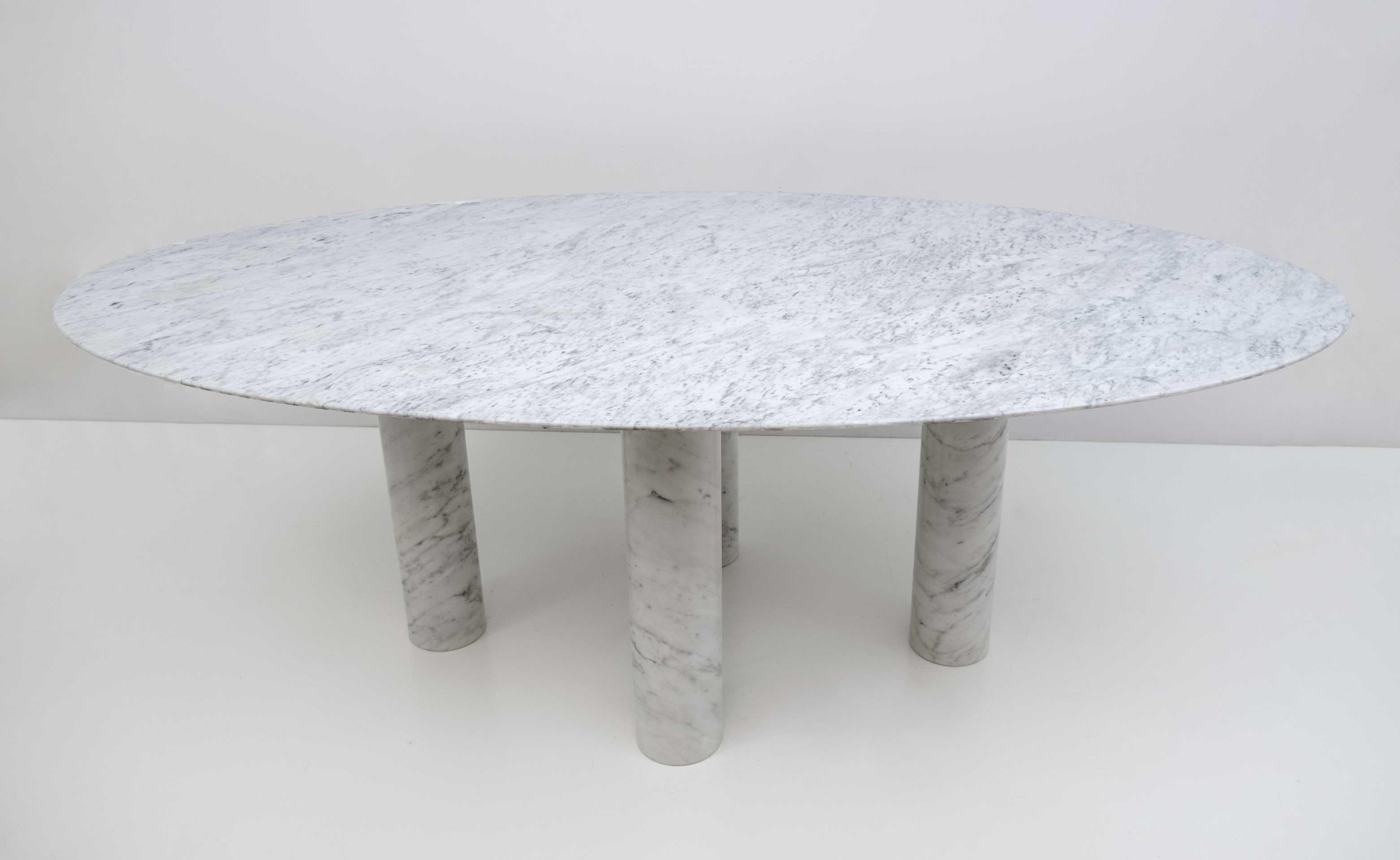 'Il Colonnato' oval dining table in white Carrara marble with evident gray veins by Mario Bellini for Cassina. The table features an oval top and four thick column legs. Bellini designed the table in the 1970s and was inspired by the architecture