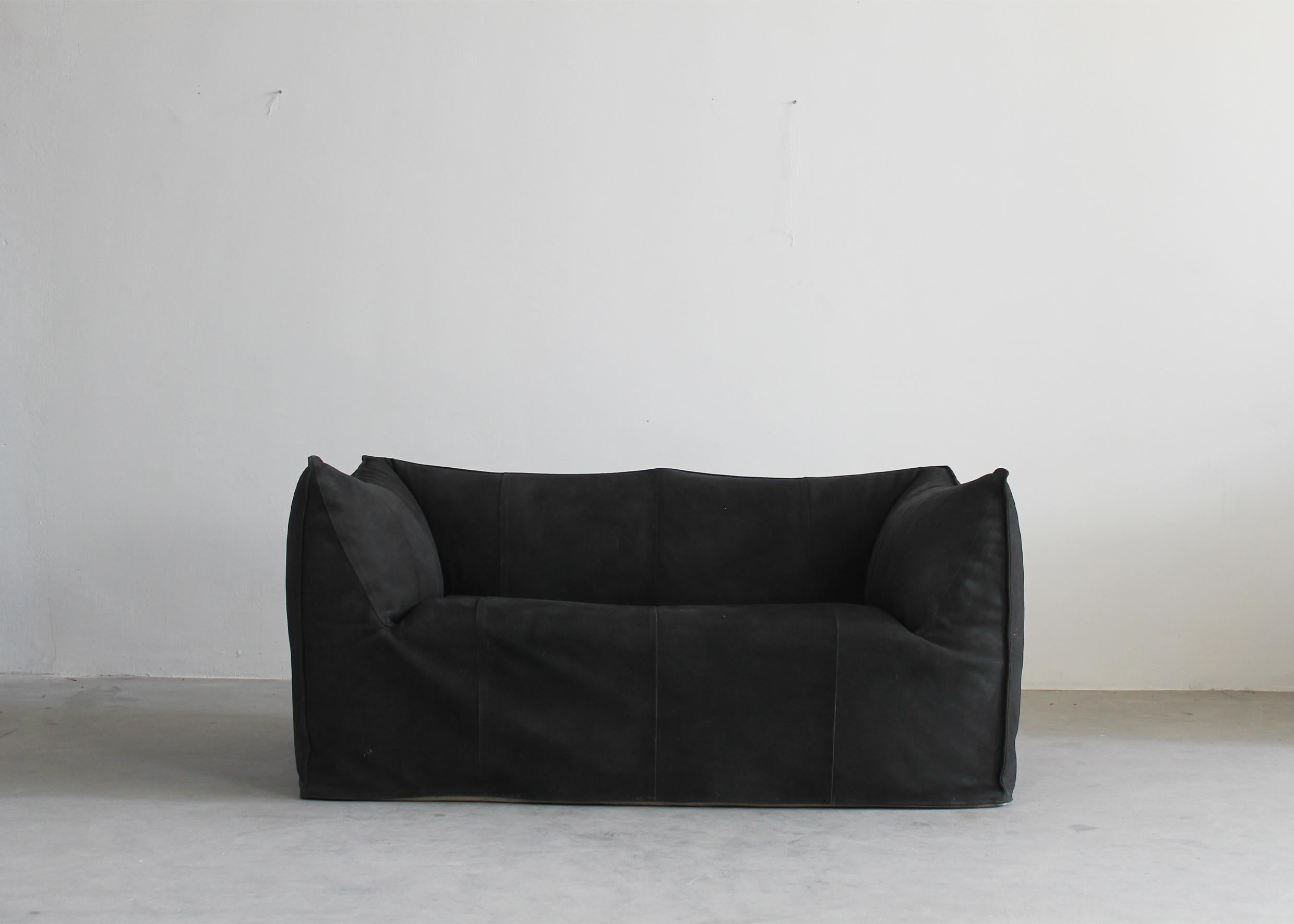 The iconic Le Bambole sofa (two.-seater) in black padded suede designed by Mario Bellini for B&B Italia 1972.

Le Bambole sofa is an icon of the Seventies and winner of the Compasso d’Oro in 1979.
Designed by 35-year-old Mario Bellini, this couch