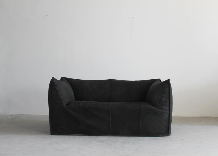 The iconic Le Bambole sofa (two.-seater) in black padded leather designed by Mario Bellini for B&B Italia 1972.

Le Bambole sofa is an icon of the Seventies and winner of the Compasso d’Oro in 1979.
Designed by 35-year-old Mario Bellini, this