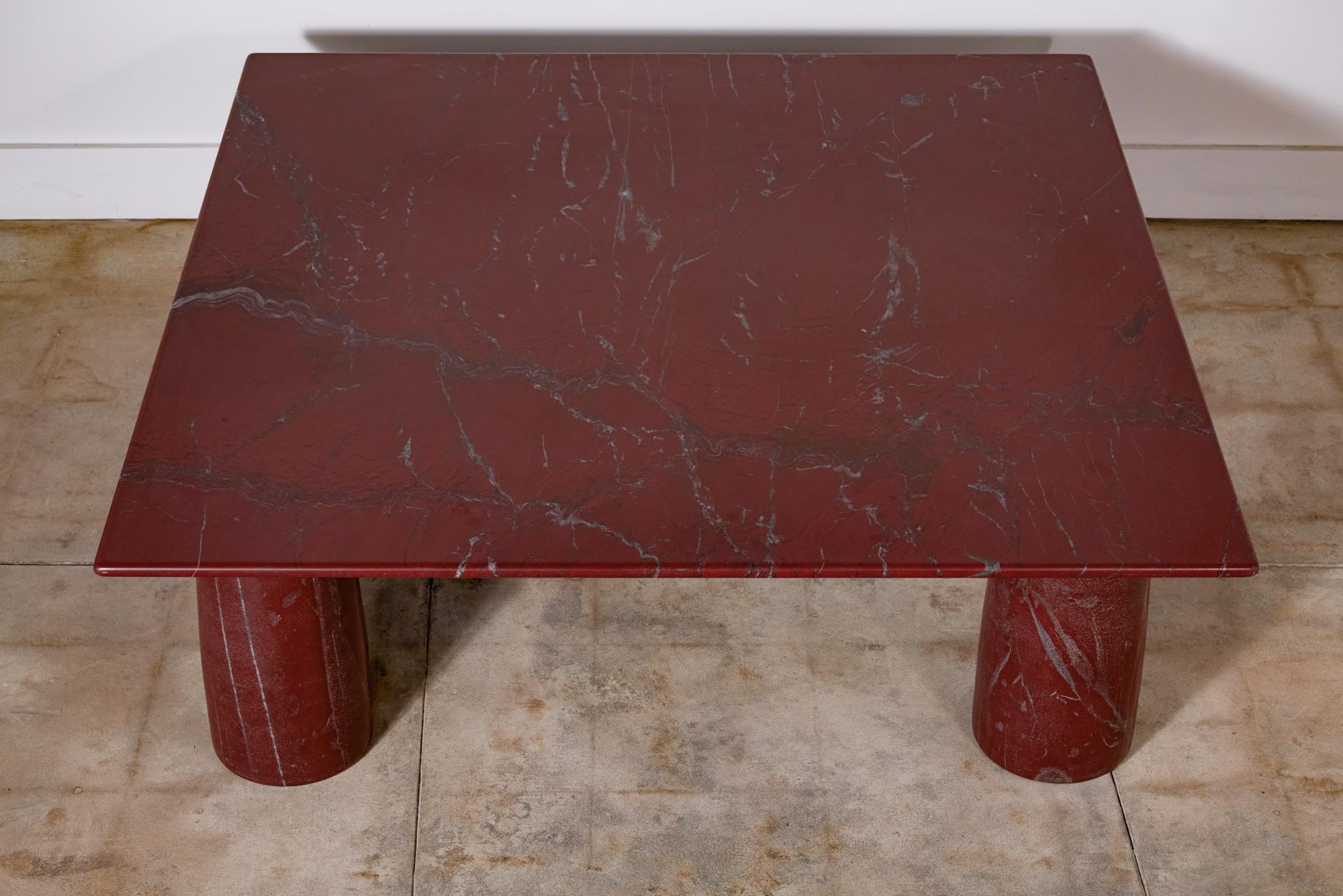 'Il Colonnato' square coffee table marble by Mario Bellini for Cassina. The table features a thick square dark red marble top with distinct gray and white veining. There are four thick column legs that support the tabletop. Bellini designed the