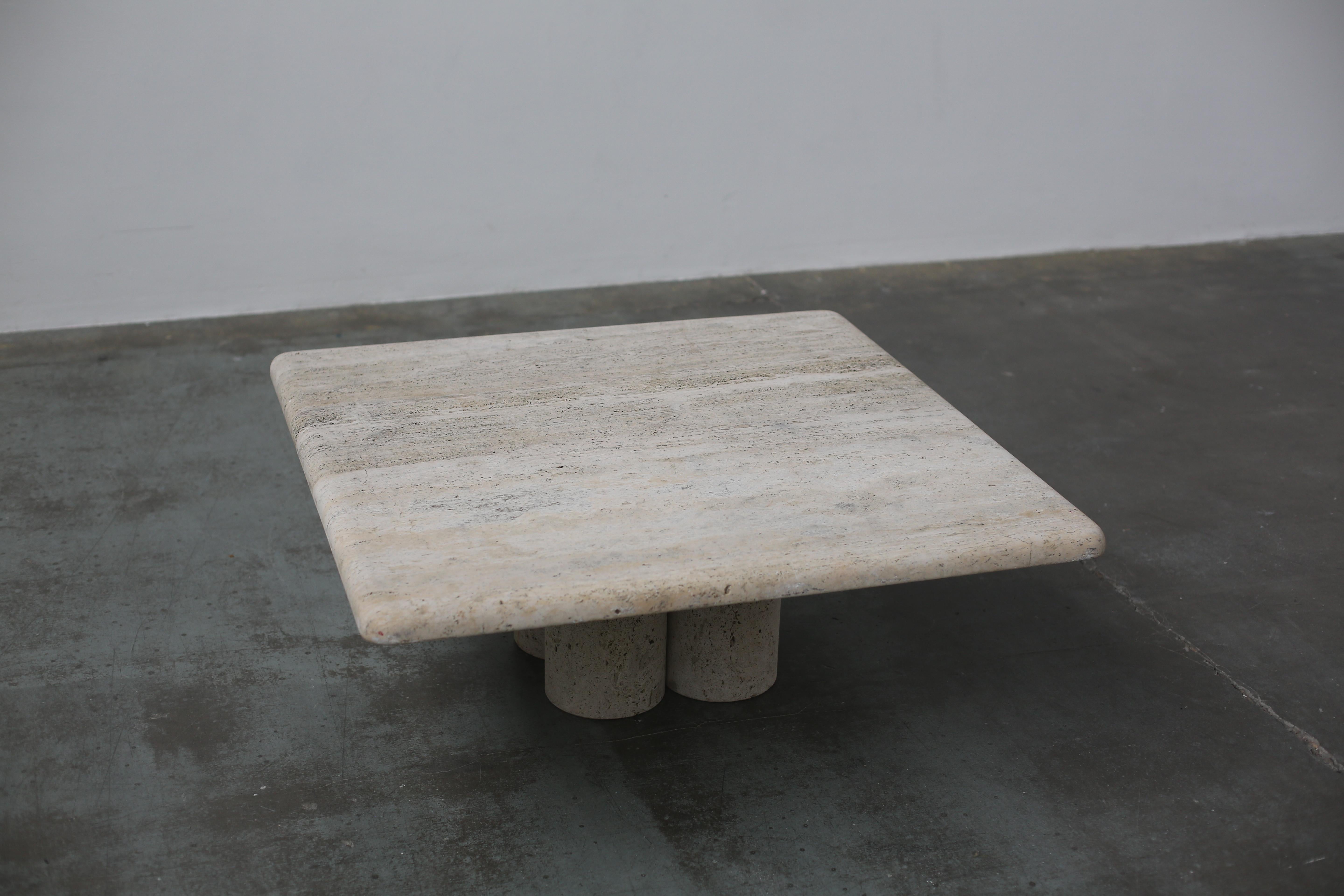 A beautiful travertine coffee table designed by the inimitable Mario Bellini for Cassina, Milan, 1975.
A square slice of striking travertine stone sits atop a base of four travertine cylinders. This heavy coffee table commands the space yet its