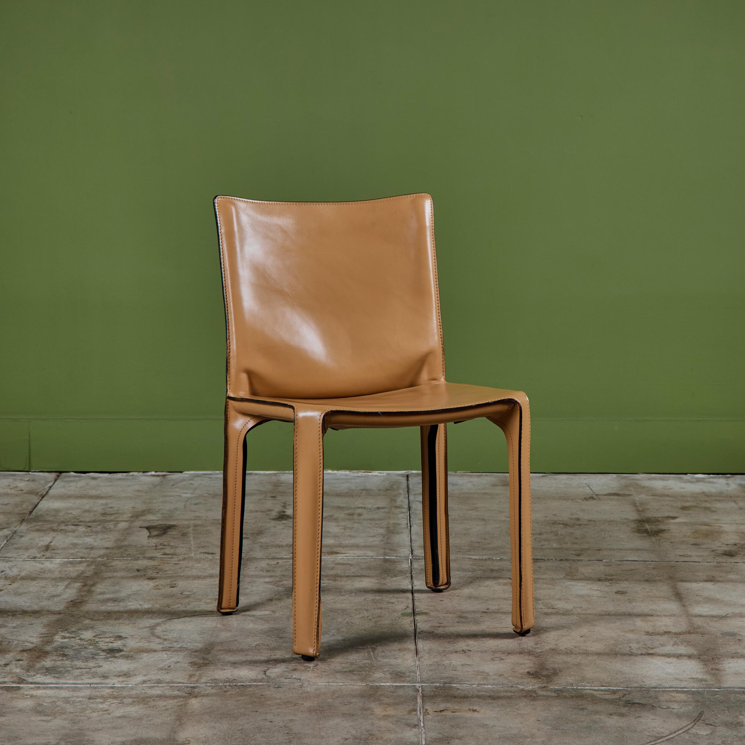 This iconic design by Mario Bellini for Cassina c.1970s, Italy, features the original natural toned saddle leather which is wrapped atop a steel frame. The back of each leg features a black zippered detail. The bottom of the chairs are marked -