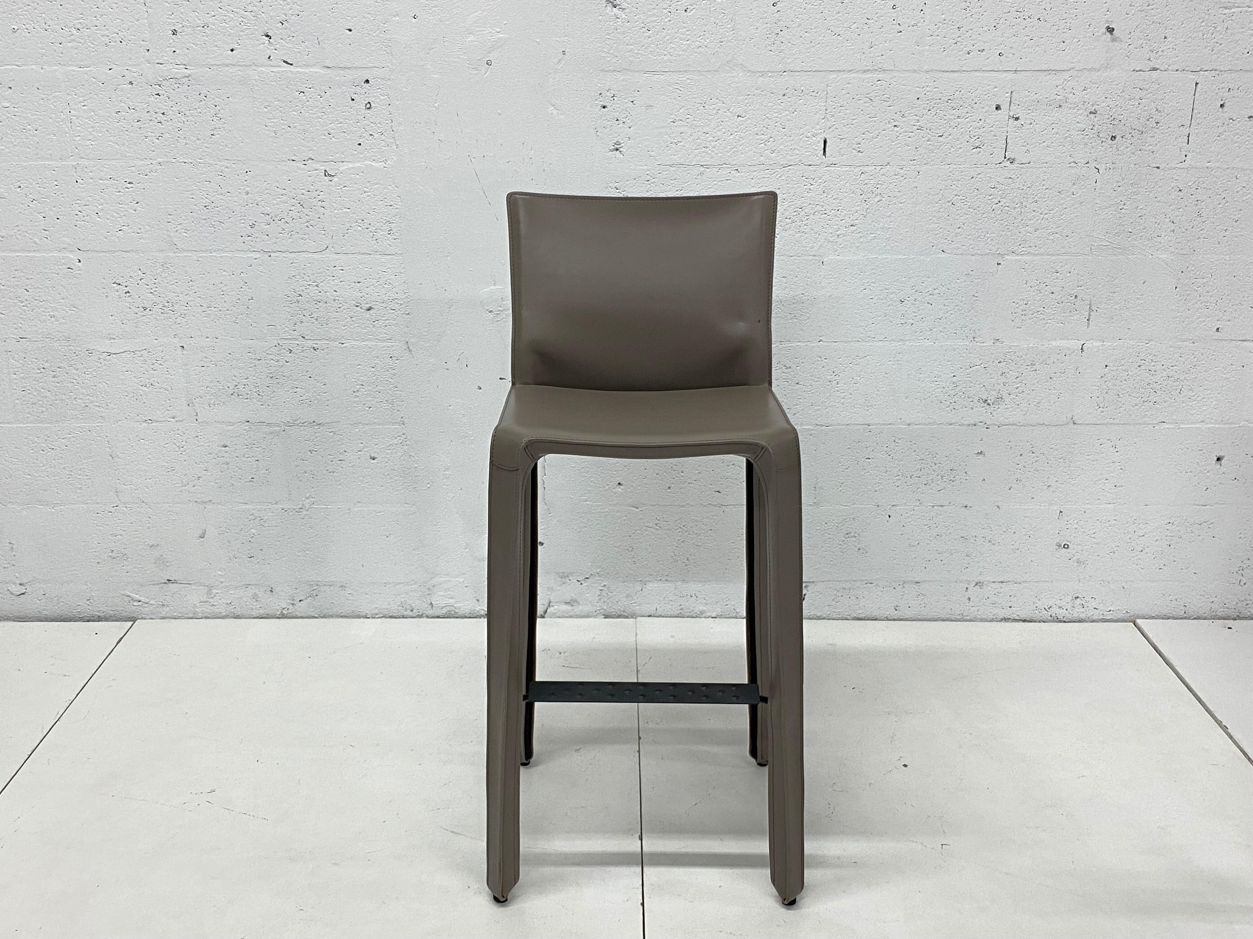 Set of four taupe gray leather bar height stools designed by Mario Bellini for Cassina. 

“This was a new kind of chair, constructed totally out of leather, much cloned since then.” Thus Mario Bellini describes Cab, a best-seller that he designed