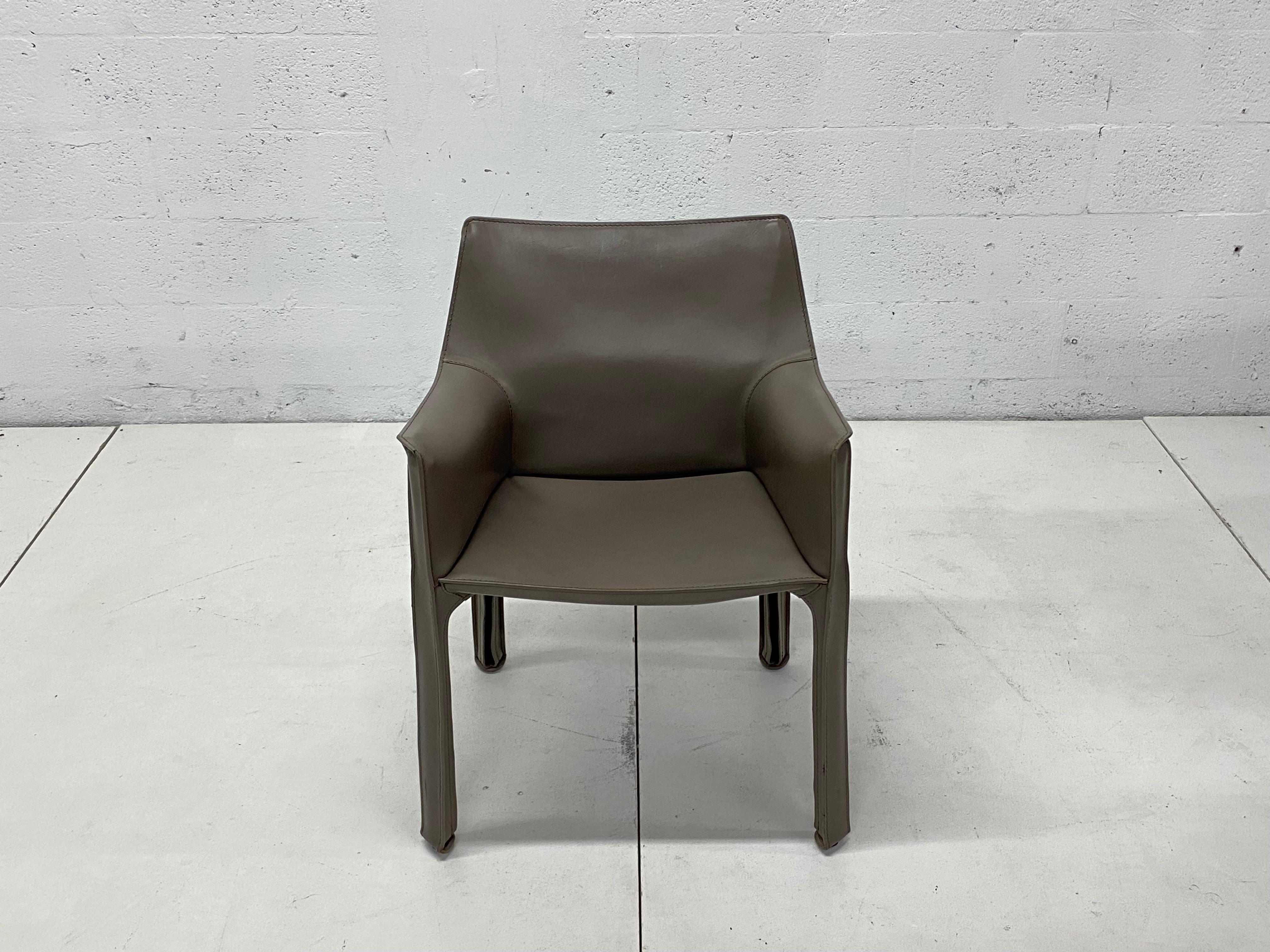 Set of four taupe gray Cab 413 leather dining or side chairs with arm designed by Mario Bellini for Cassina. 

“This was a new kind of chair, constructed totally out of leather, much cloned since then.” Thus Mario Bellini describes Cab, a