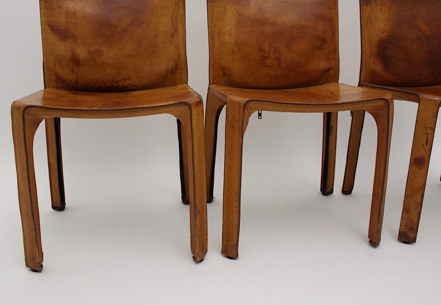 Three vintage dining chairs model CAB 412 from stitched leather in tan or cognac brown color tone
 by Mario Bellini 1977, Italy.
Iconic dining chairs, which were made from metal skeleton and stitched saddle leather.
Throughout the color tone and