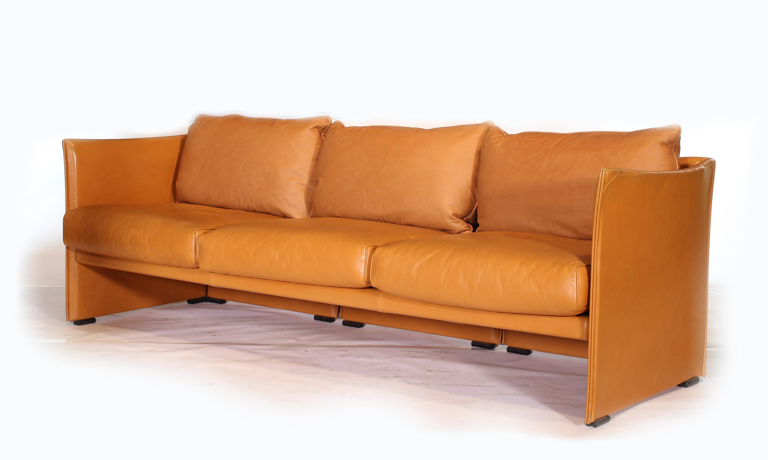 Authentic vintage Mid-Century Modern three-seat tilbury sofa by Mario Bellini in light brown leather. Three back cushions have been replaced to a close match. Measures: 84