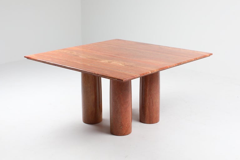 Mario Bellini 'Il Colonato' table, red travertine, Italy, 1970s.

For this series of tables, Bellini was inspired by ancient Roman columns. This table consists of four cylindrical legs and this model features a square tabletop. The red colored