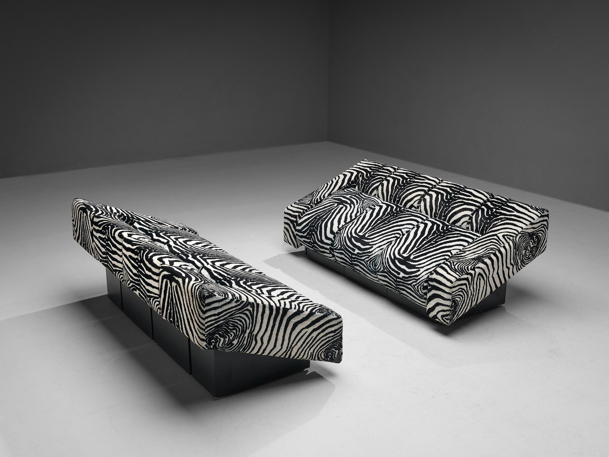 Mario Botta for Alias, pair of sofas, model ´Obliqua´, fabric, black lacquered wood, Italy, circa 1983. 

Bold pair of 'Obliqua' sofas designed by Mario Botta for Alias. Upholstered in eccentric zebra print fabric, this set will definitely stand out