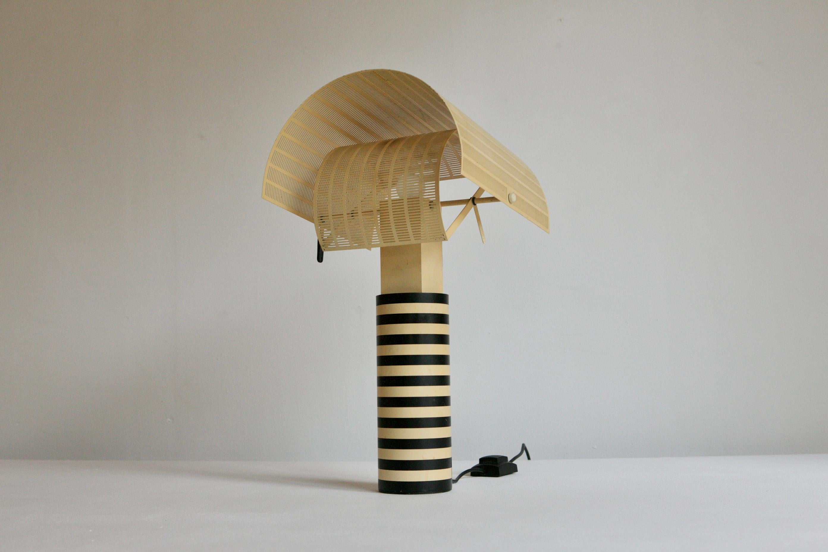 An original Shogun lamp that was designed by Mario Botta for lighting manufacturers Artemide. The iconic lamp was a ground breaking postmodern design with it's striped beacon base. It has perfect function with it's perforated rotating shades.  It's