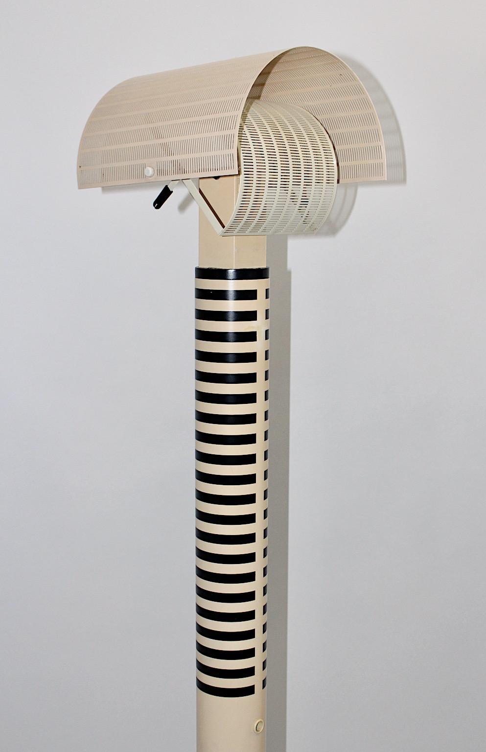 Modern vintage floor lamp designed by Mario Botta 1980s for Artemide Italy from ivory and black striped aluminum and tubular steel.
The gorgeous construction shows geometric elements, which the designer Mario Botta loves to integrate in his