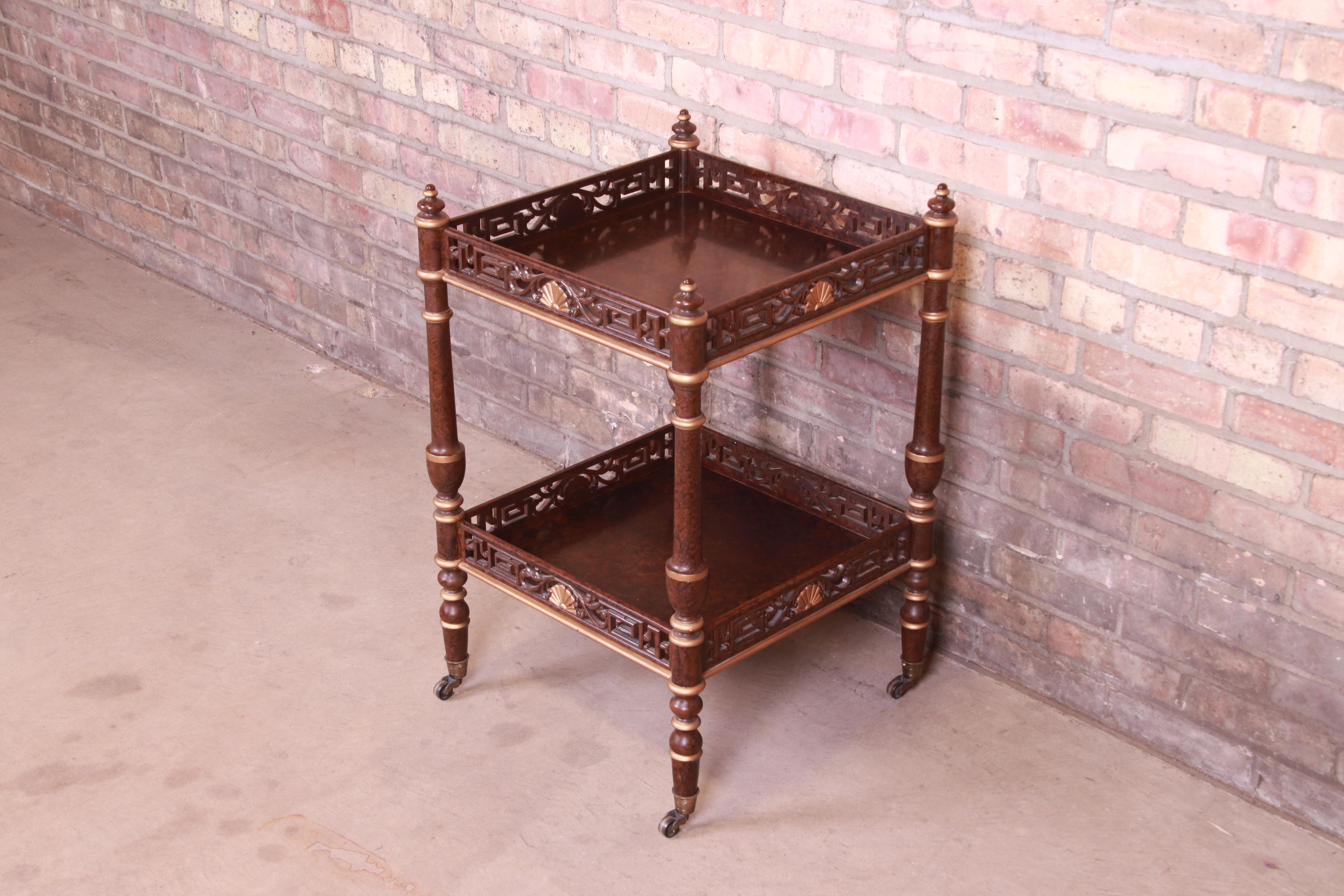 A gorgeous Hollywood Regency Chinoiserie two-tier occasional side table or tea table on casters

By Mario Buatta for John Widdicomb

USA, circa 1980s

Carved wood in faux tortoise shell finish, with gold gilt accents.

Measures: 19.25