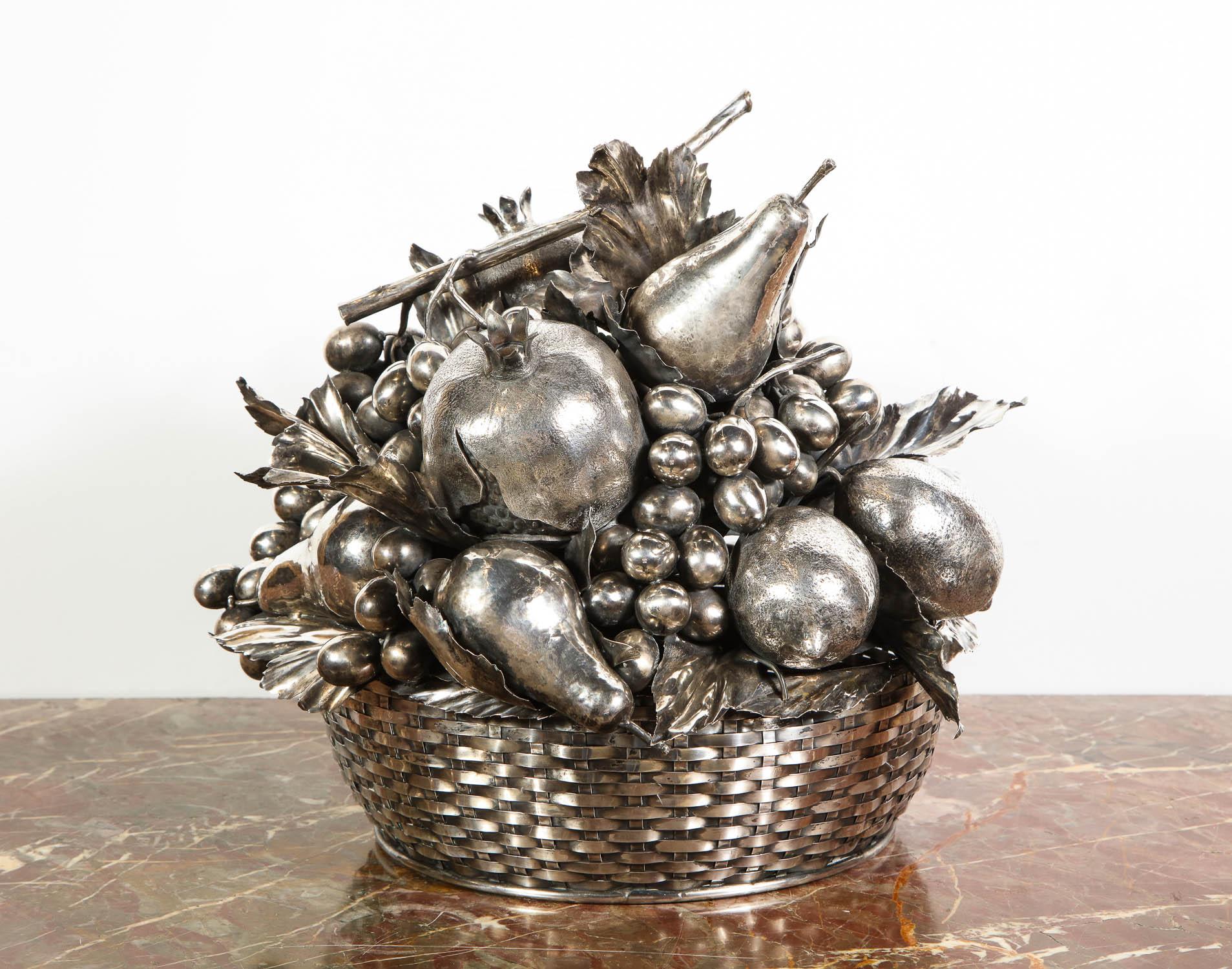 Mario Buccellati, a large Italian silver fruit basket centerpiece

The woven sterling silver basket, topped by a removable textured and sculpted sterling silver arrangement of fruits (pomegranates, pears, grapes, lemons, and leaves).

The grape