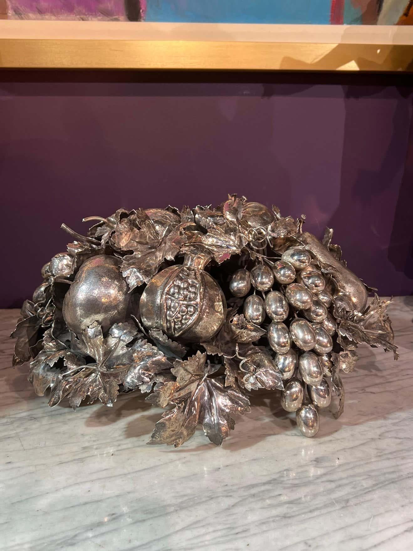 Mario Buccellati, An Italian Silver Fruit Basket Centerpiece and Bowl, Milan 20th century  

The oval basket centerpiece is formed with woven bands, the lift-off cover is realistically a modeled as a group of fruits and leaves including grapes,