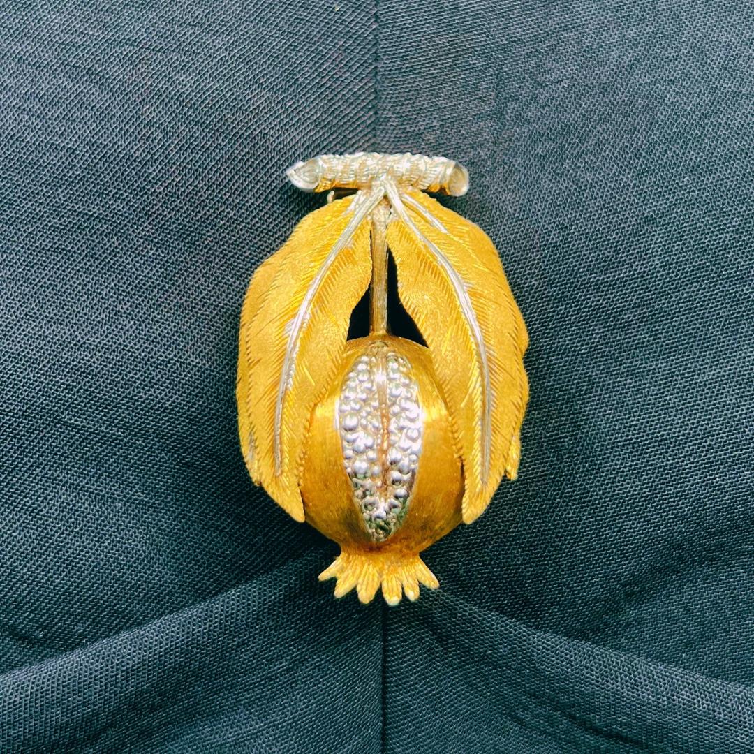 Una straordinaria spilla a baccello di melograno in oro 18 carati bicolore bianco e giallo di Mario Buccellati, Italia. 

Si tratta di una spilla a forma di melograno finemente lavorata con il timbro 