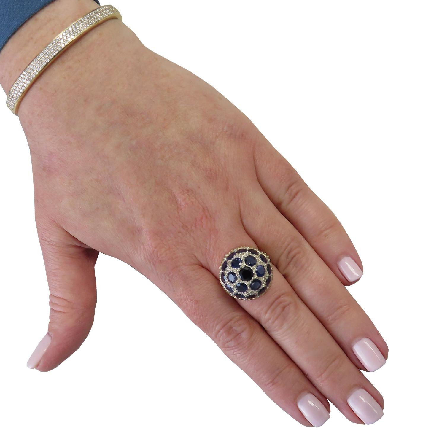 Vintage Mario Buccellati bombe ring circa 1950, featuring 19 round blue sapphires weighing approximately 8.5 carats total. This ornate domed ring measures 19 mm in diameter and 11.7 in height. The band measures 2mm, tapering gently to 1.45 mm. It is