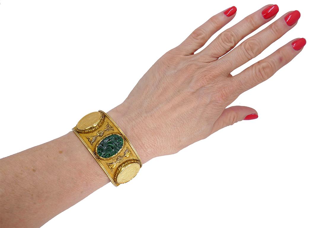  A rare Mario Buccellati gold coin bracelet, featuring carved jade. 
This sculptured bangle bracelet carries four antique coins. All the coins are bezel set and mounted into beautiful, pierced frames. Two gold framed carved jade elements have