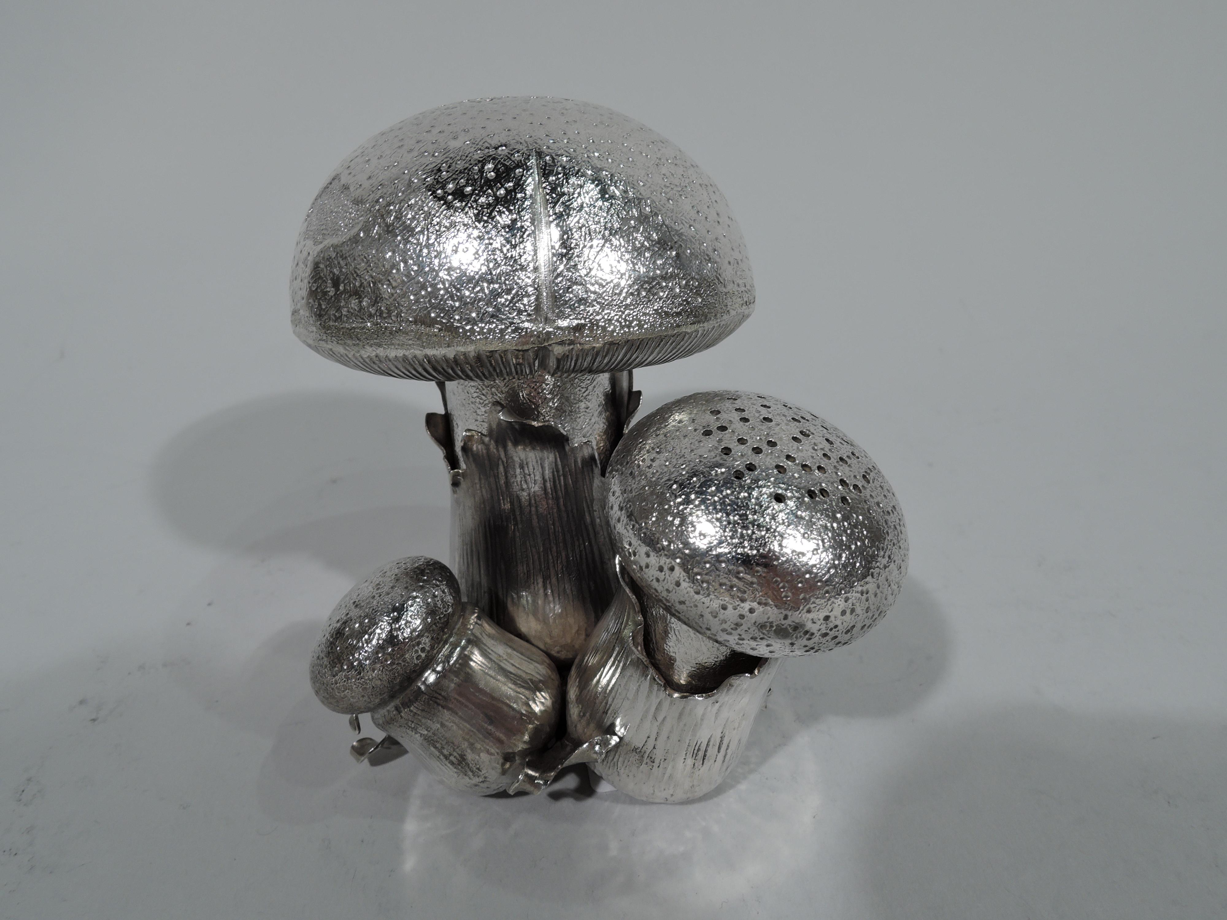 Mid-Century Modern sterling silver salt and pepper shakers. Made by Mario Buccellati in Italy. Figural in form of three mushrooms with irregular and stippled caps and striated stalks mounted to leaf frame. Two mushrooms are detachable with pierced