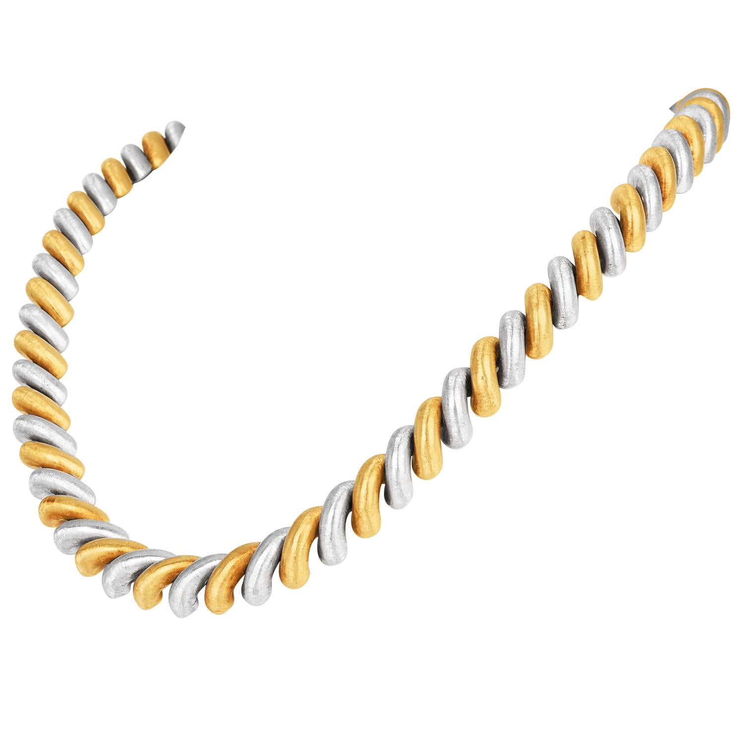 Le collier Torsadé de Mario Buccellati incarne la maîtrise du design sculptural de la maison. Fabriqué à partir de maillons d'or jaune et d'or blanc alternés, chaque maillon, d'une largeur de 10 mm et d'une finition satinée douce, mesure 16 pouces