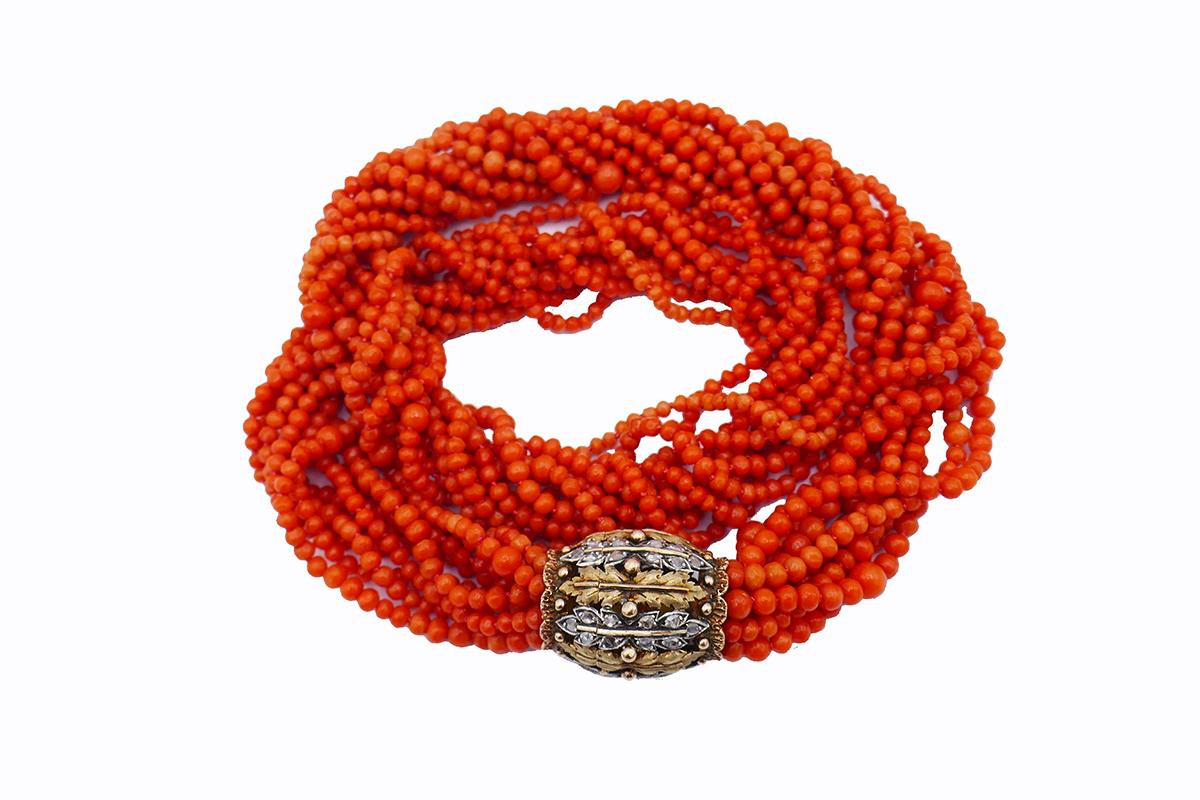  A stunning Mario Buccellati coral bead necklace featuring a diamond and 18k gold ornate clasp. This vintage Buccellati necklace is composed of ten coral strands with the beads of irregular sizes. The strands are bundled together by the gold barrel