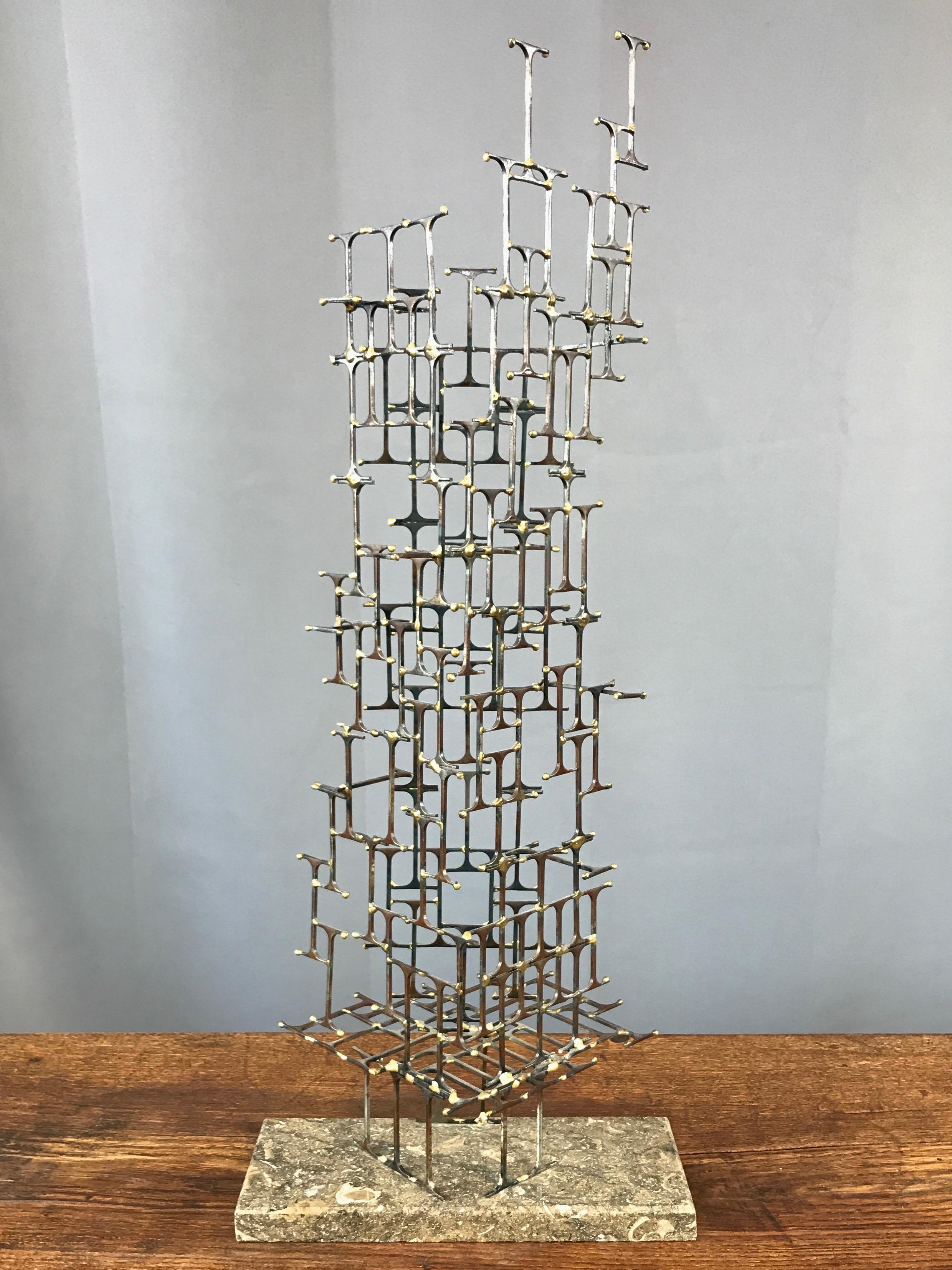An exceptional tall Brutalist abstract metal sculpture on travertine base by Mario Jason, signed and dated.

Architectural form of I-beam-shaped iron nail elements with brass welds and tip accents. Artfully composed and complex cantilevered