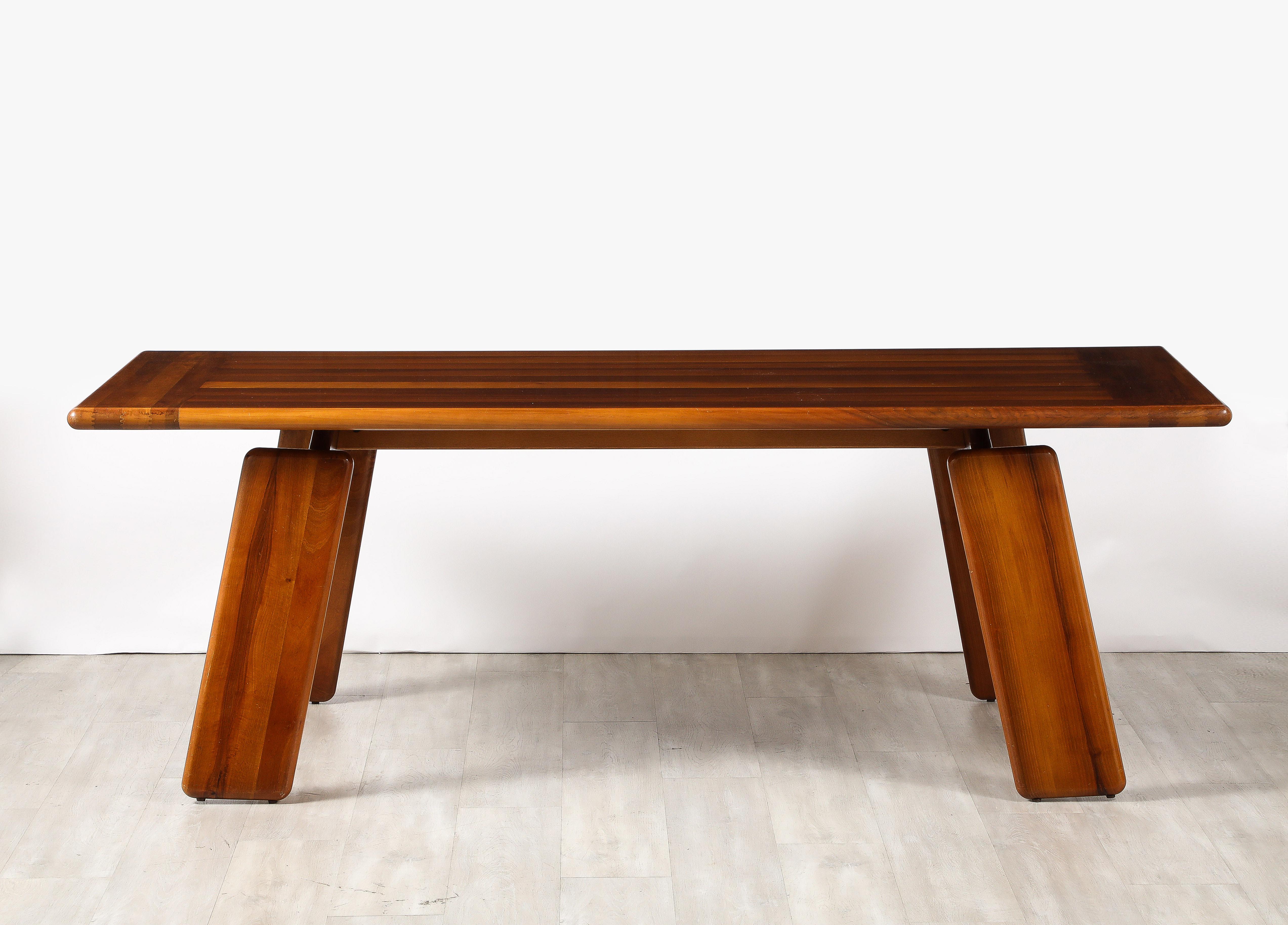 An Italian walnut floating dining table designed by Mario Marenco, for Mobil Girgi, 1970's. The canted legs are connected to a horizontal stretcher, which support the top, creating the visual effect of a floating table top. The surface wood is
