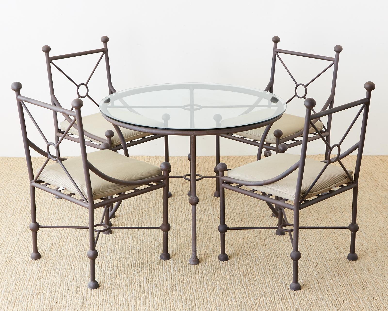 Dramatic aluminum garden or patio dining table made in the style of Mario Papperzini for Salterini. Features a ball finial motif with a target design in the center and neoclassical style klismos legs. Topped with a round pane of glass the finish has