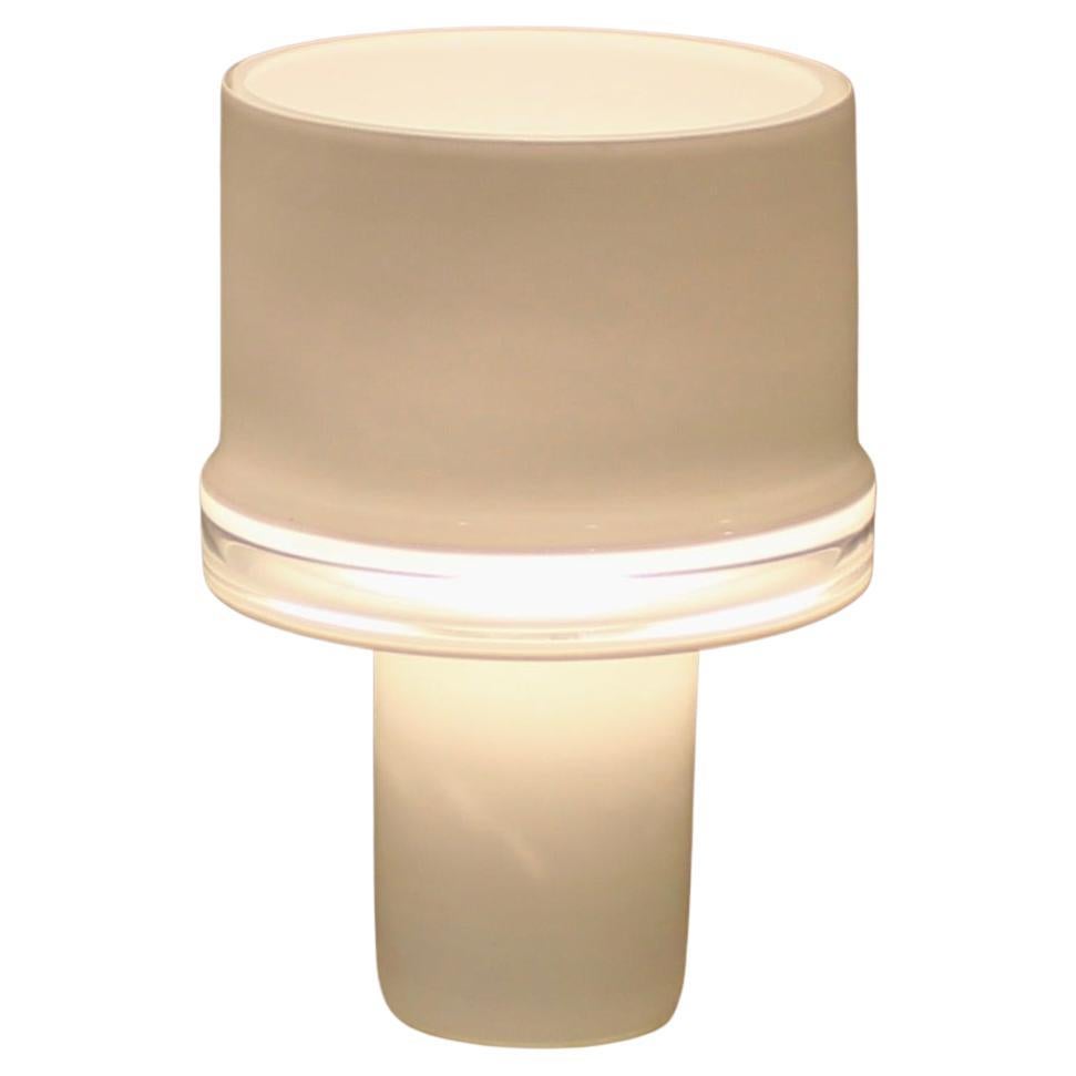 Mario Ticco for Venini Murano table lamp. Cased opaque white single glass table lamp with a clear center to allow the light to emit and glow. Open at the top for uplight with the clear center. One piece not fused or assembled. Rewired with standard