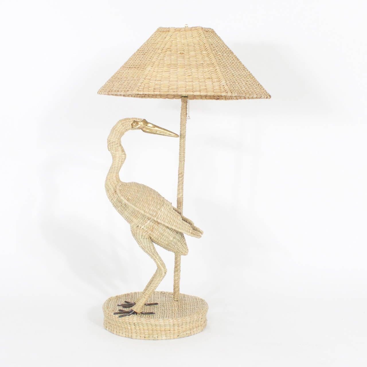 Amusing Mario Torres Egret table lamp constructed of a metal frame wrapped in wicker or reed. Featuring a brass beak, eyes and metal feet. Signed on the bottom Mario Torres, 1974.