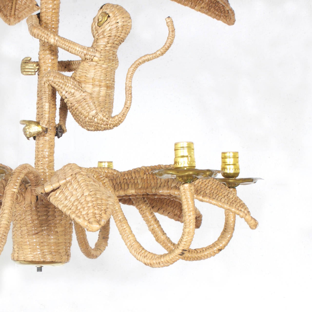 Amusing Mario Torres six-light chandelier constructed of a metal frame wrapped in wicker or reed in a tight intricate pattern. Featuring a wicker monkey with a brass face, hands and feet that is climbing a palm tree. Signed Mario Lopez Torres 1974