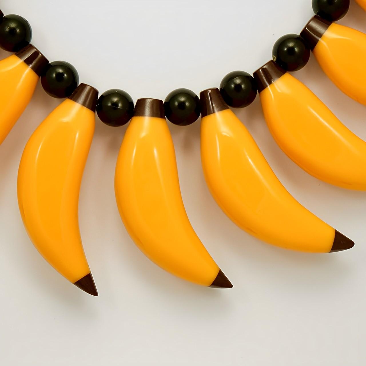 Marion Godart fantastic yellow and black shiny plastic bananas, with round black plastic beads, and a hook clasp. The necklace is length 48.3 cm / 19 inches. The largest banana is length 5.6 cm / 2.2 inches. It is in very good condition, as