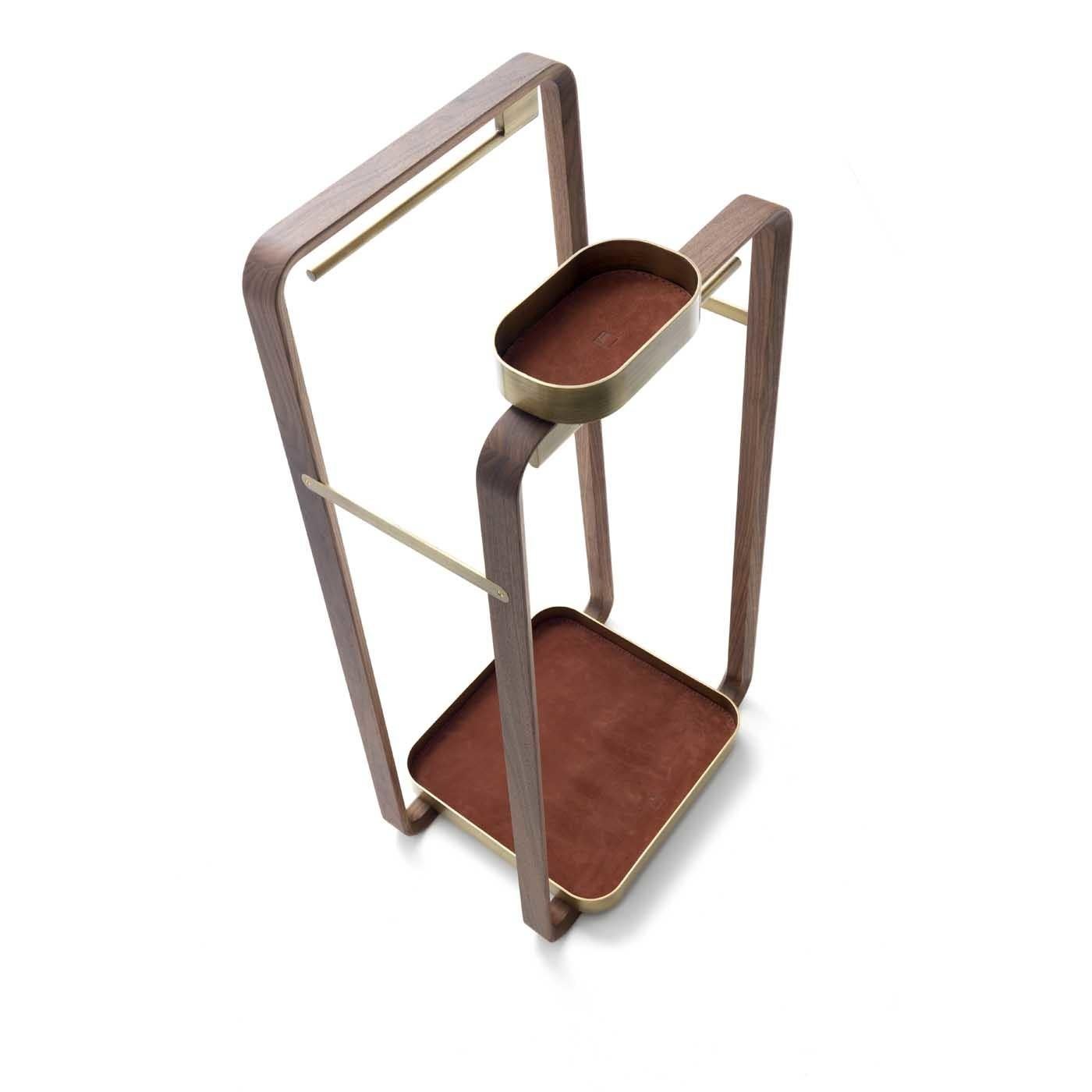 This valet stand is a versatile and precious addition to a contemporary decor, while also being a superbly decorative accent that will enliven a bedroom with its sculptural allure. The metal tray with a satin-brass finish at the base is upholstered
