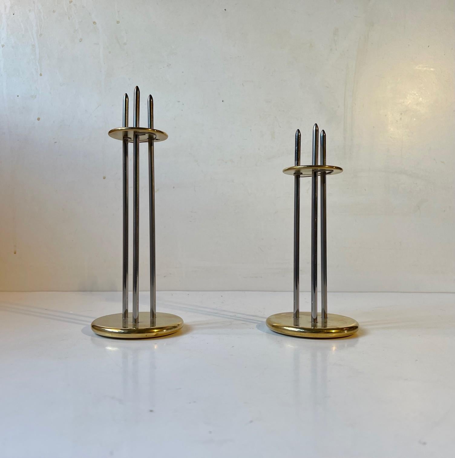 A set of height-adjustable candleholders for regular sized candles. Designed by the danish engineer Peter Seidelin Jessen for his own company Delite during the 1980s or 90s. They are made from mirror-polished stainless steel and gilded brass.