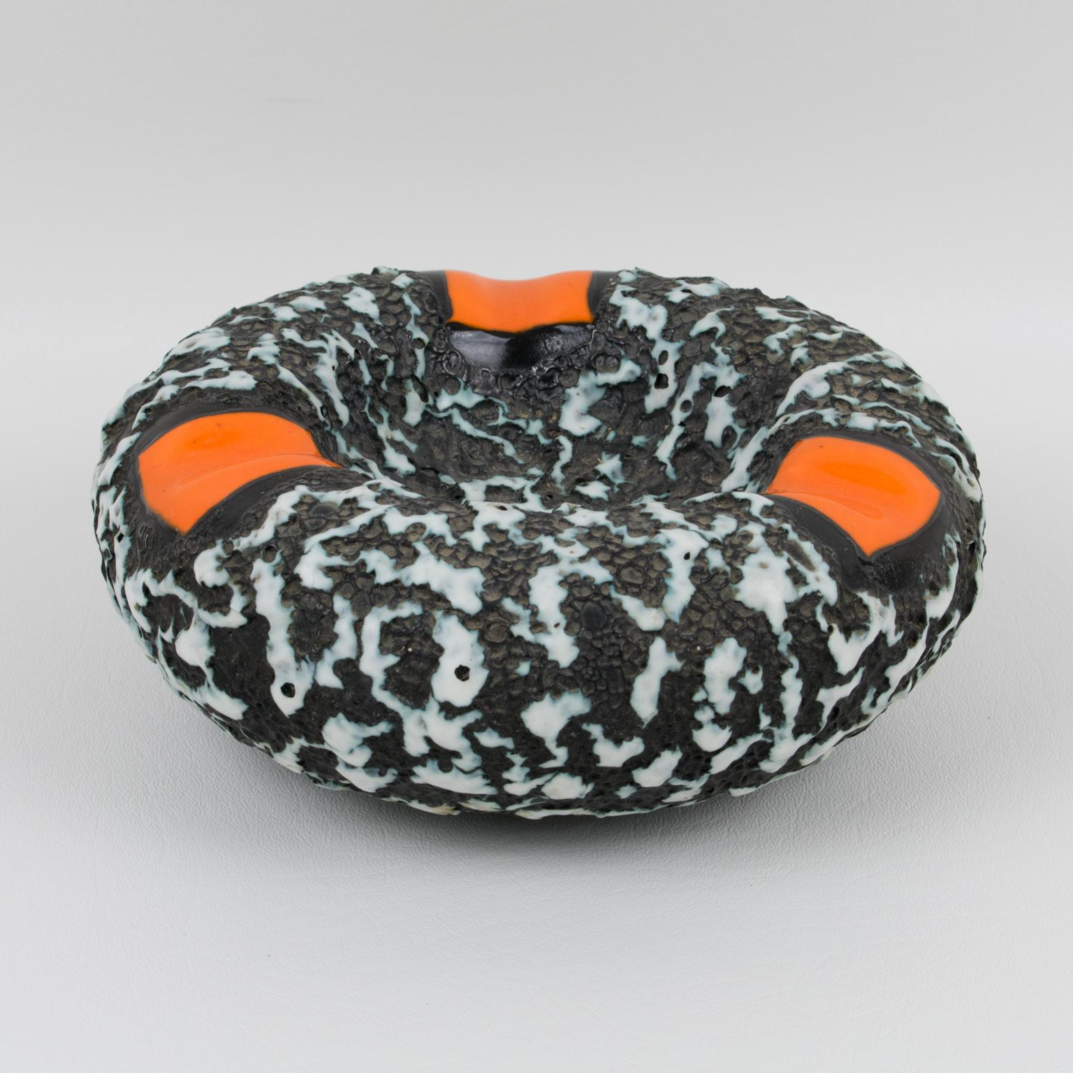 Lovely 1960s French ceramic cigar ashtray, desk tidy, vide poche, or catchall, reminiscent of Marius Giuge in Vallauris, work. Extra thick rounded donut shape with a lava textured pattern, in black and white colors with bright orange accents. No