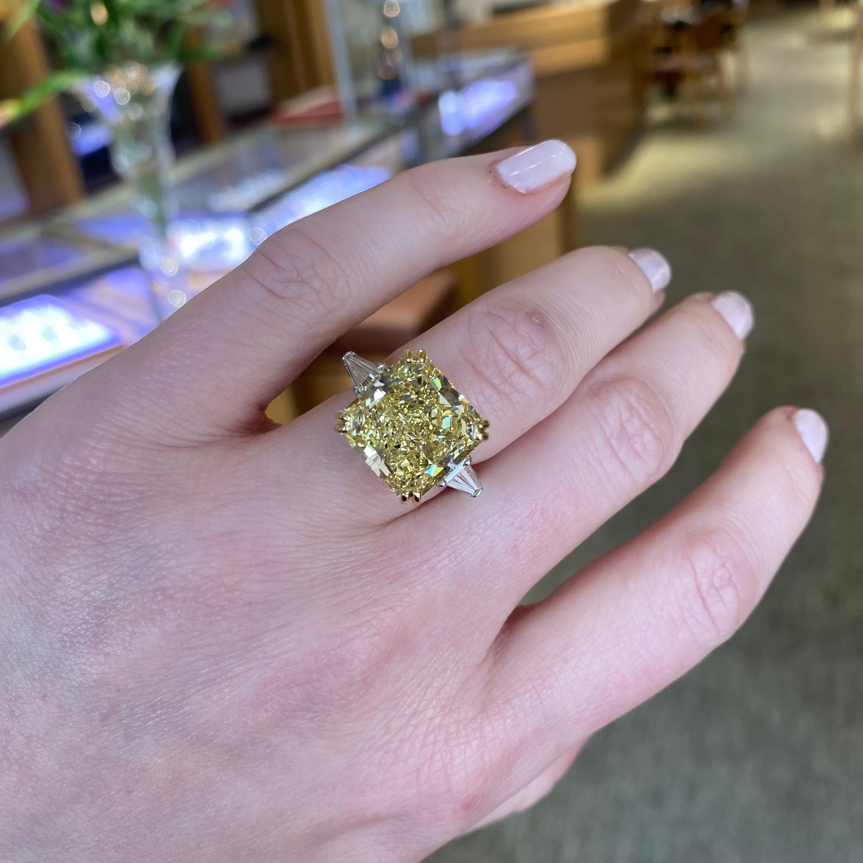 Designed and handmade by Mark Areias Jewelers in Platinum and 18 karat yellow gold. Set with one important vibrant fancy yellow cushion cut diamond and two (2) tapered baguette diamonds. The vibrant center diamond is set in 18 karat yellow gold with
