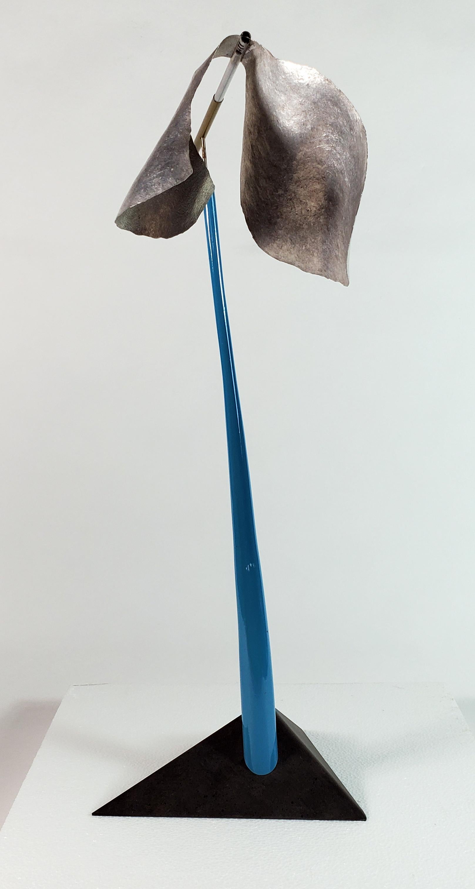 Cloud Constructions
This elegant and playful sculpture is kinetic (characterized by movement). The painted steel, vertical, sky-blue stalk creates the fulcrum or support for the horizontal element. The motion of the “weathervane” is created by the