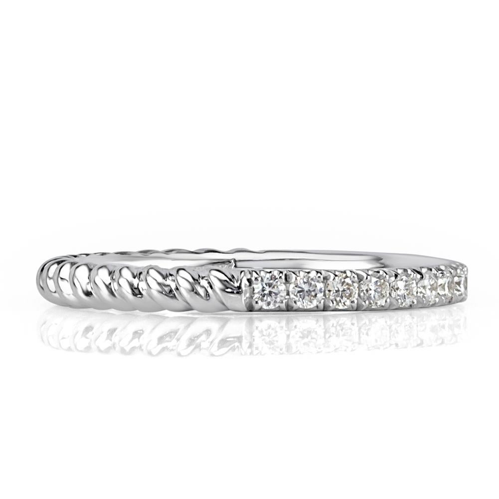 Handcrafted in 18k white gold, this feminine diamond wedding band features an exquisite design of half circle diamonds and half circle rope texture. The round brilliant cut diamonds total 0.30ct in weight and are graded at E-F, VS1-VS2.