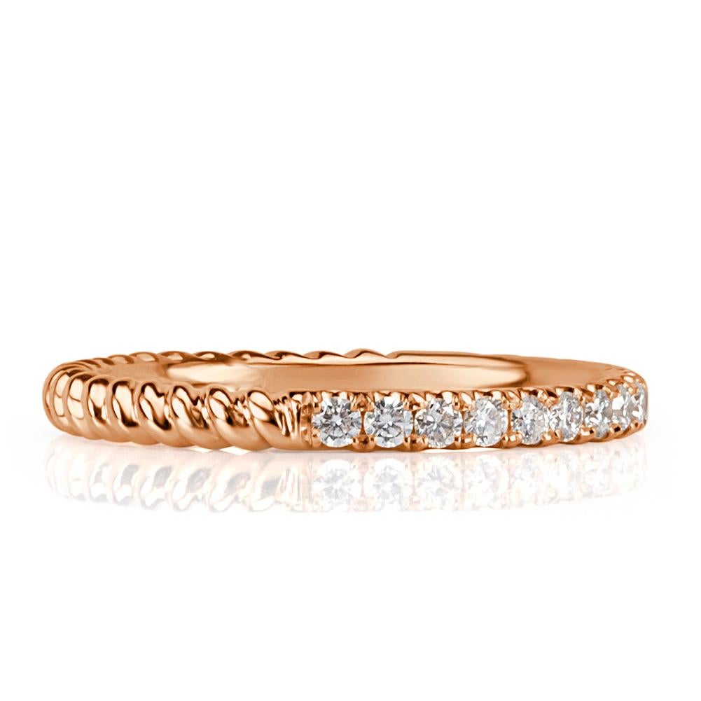 This 18k rose gold diamond wedding band showcases an exquisite design of half circle round brilliant cut diamonds and half circle rope texture. The diamonds total 0.30ct in weight and are graded at E-F, VS1-VS2.