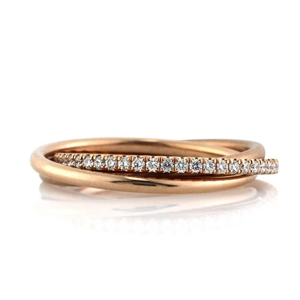 This round brilliant cut diamond trinity eternity ring features three bands beautifully intertwined. One is set with round diamonds in a micro pave setting, the other in a satin finish and the third with a high polish finish, all in 14k rose gold.