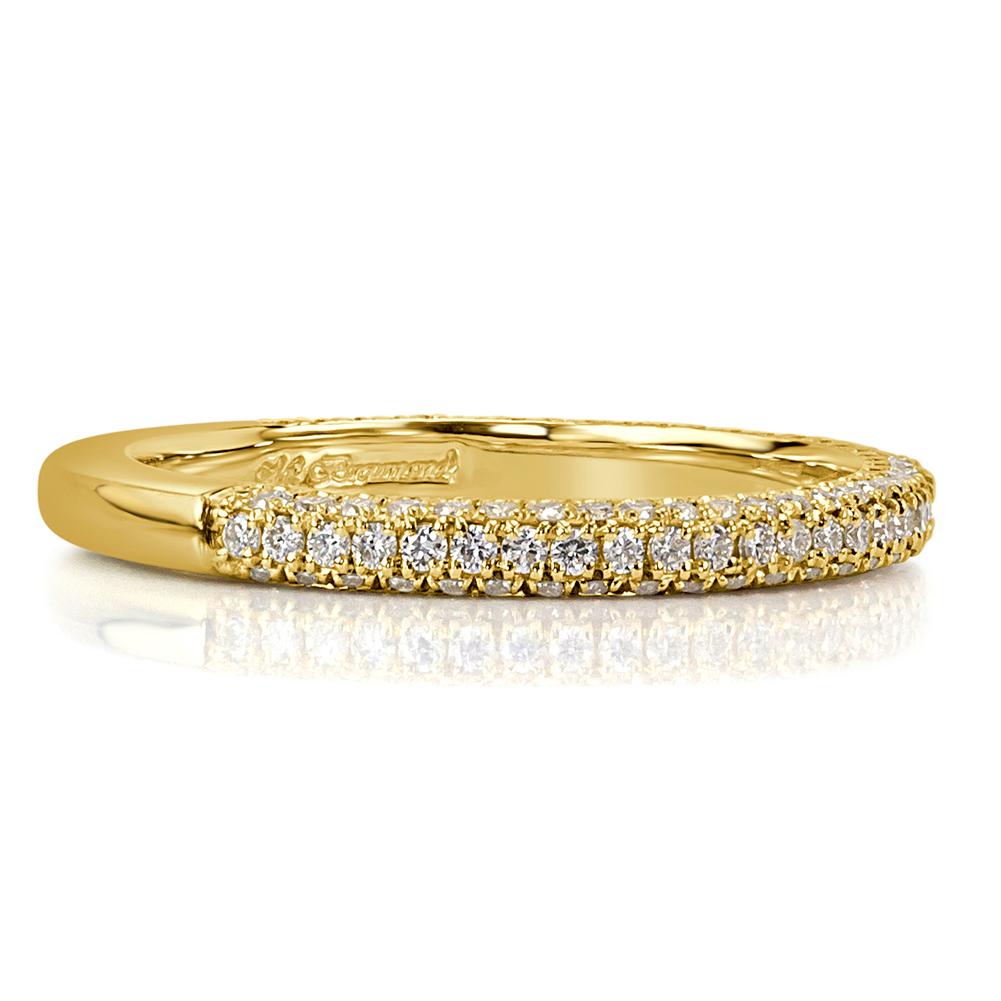 This mesmerizing diamond wedding band features three rows of round brilliant cut diamonds micro pavé set in 18k yellow gold. The diamonds total 0.60ct in weight and are graded at E-F in color, VS1-VS2 in clarity.