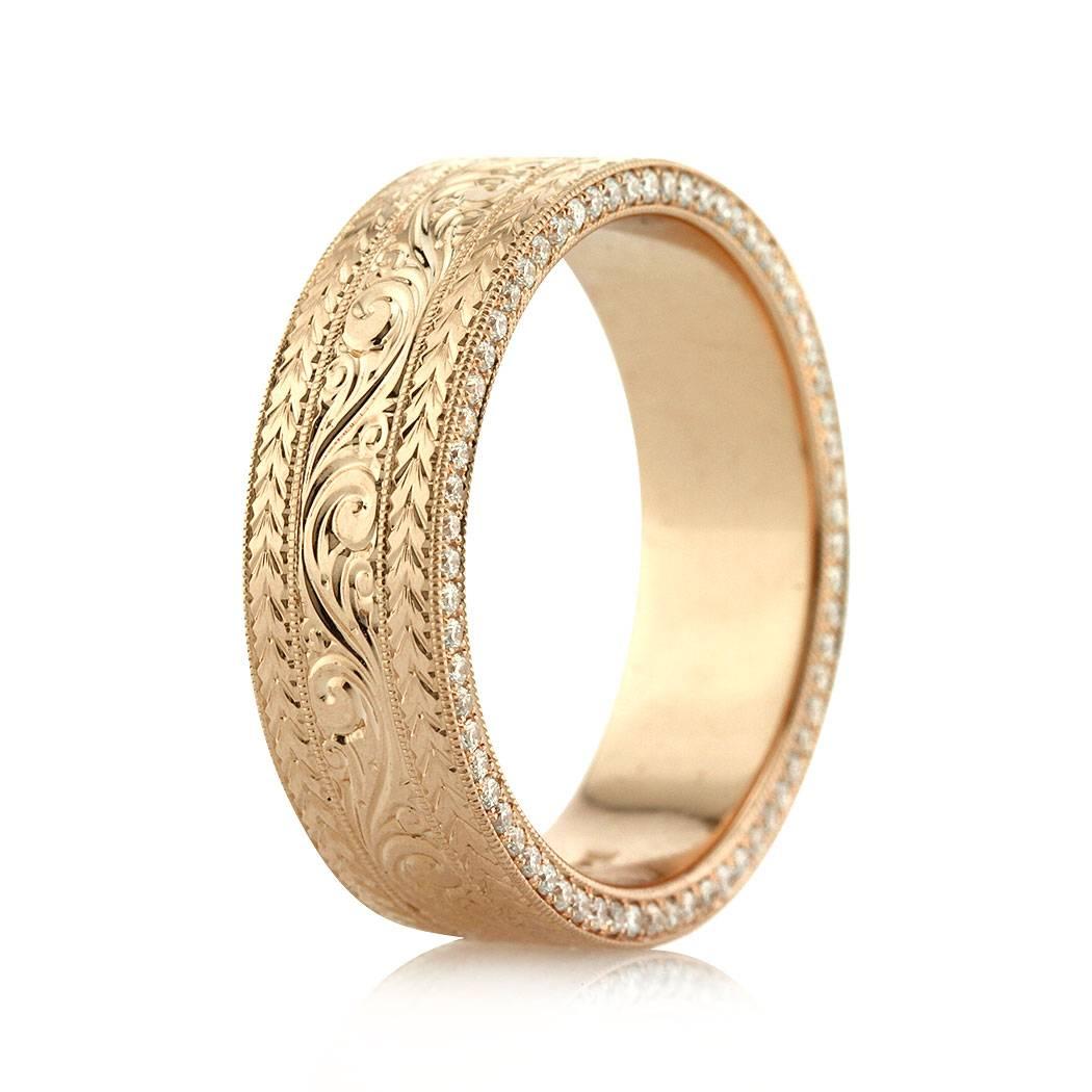 This stunning 14k rose gold men's wedding band features intricate hand engraved details throughout its circumference. For added shimmer, round brilliant cut diamonds are set along both edges as well. The accent diamonds are graded at E-F, VS1-VS2.