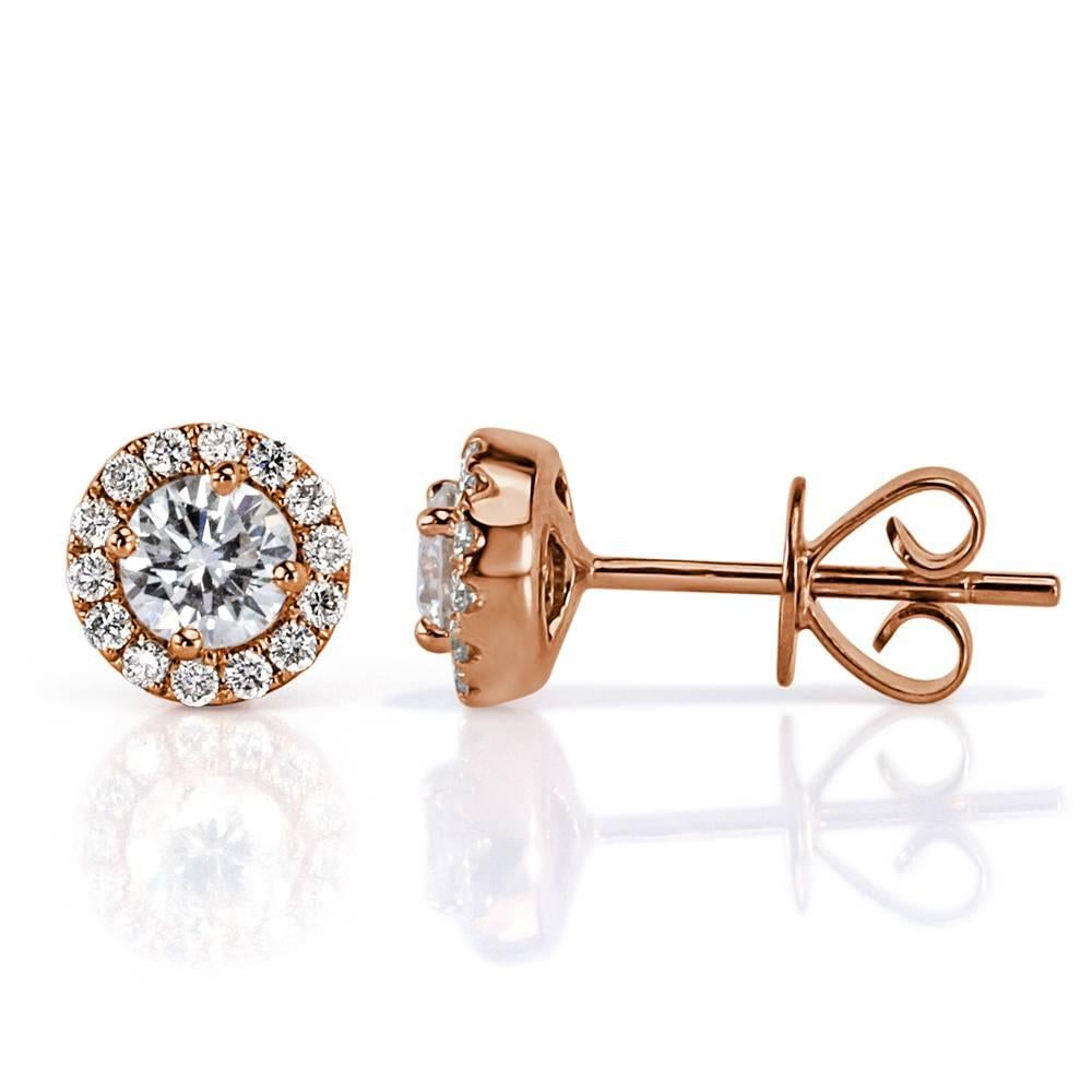 This exquisite pair of diamond stud earrings showcases 0.70ct of round brilliant cut diamonds micro pavé set in 14k rose gold. Each of the two sparkling center diamonds is surrounded by a halo of smaller round brilliant cut diamonds. All of the