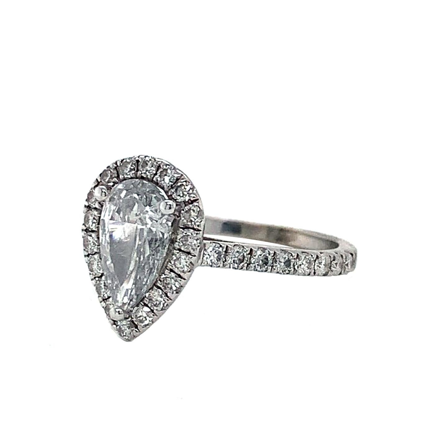 Dieser faszinierende Verlobungsring aus Platin ist mit einem birnenförmigen Diamanten von 0,91 Karat besetzt, der vom GIA zertifiziert wurde. Ein schimmernder Halo aus runden Diamanten im Brillantschliff sowie eine Reihe funkelnder Diamanten in